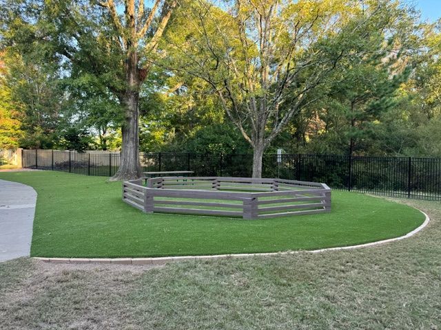 There is a wooden fence in the middle of the grass.