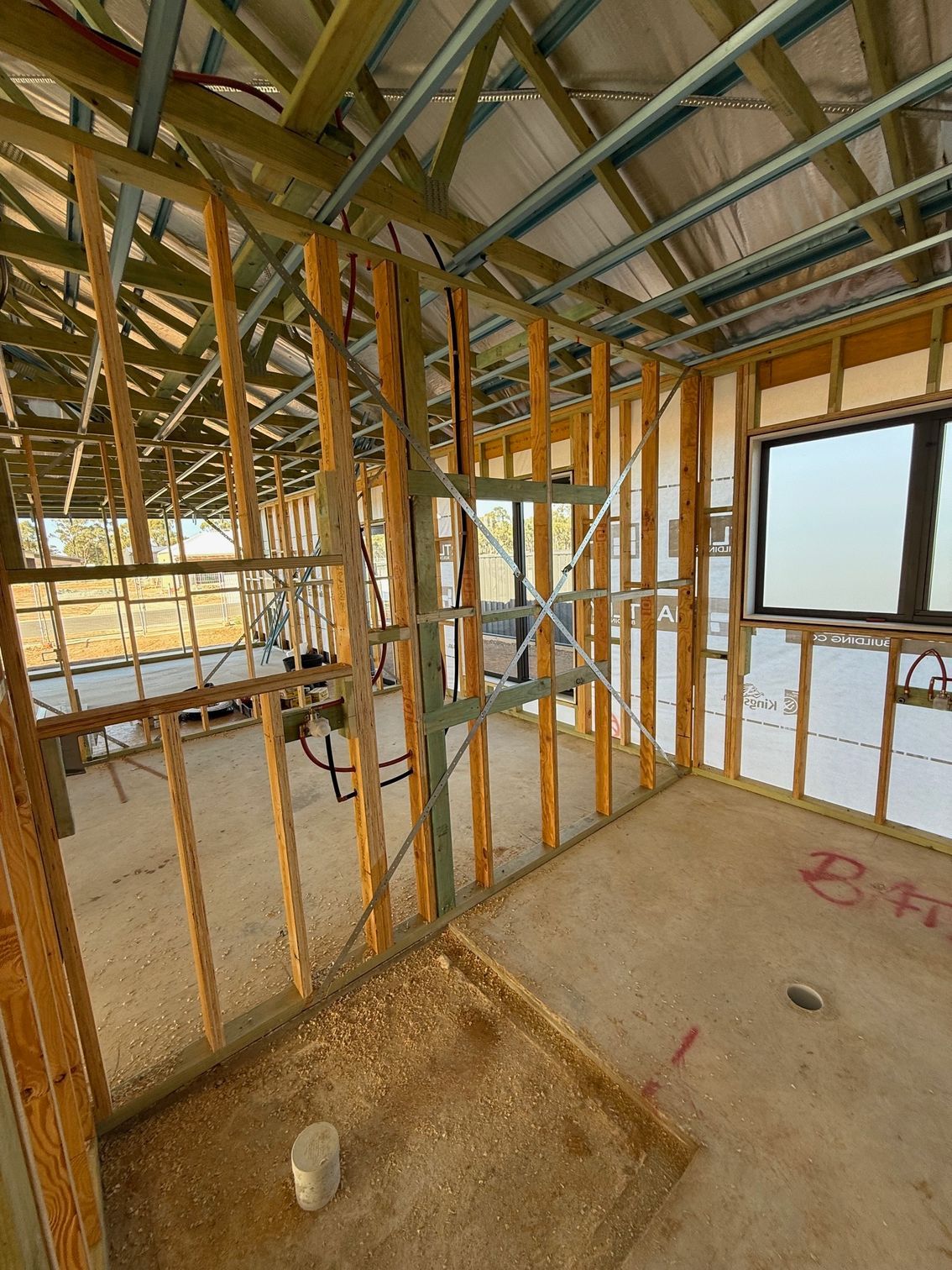 A room under construction with wooden beams and a window.