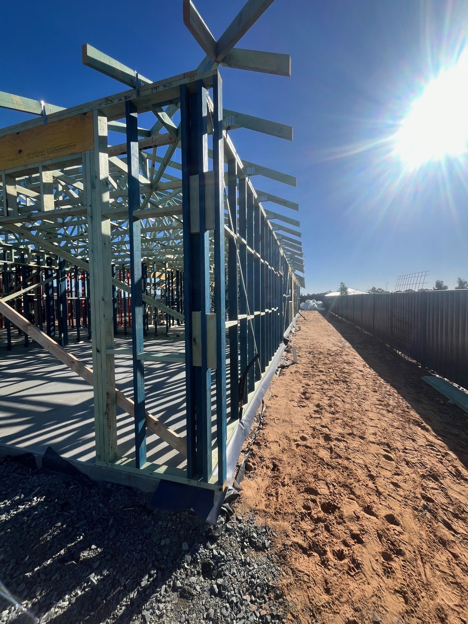 Construction site with wood framing against a bright blue sky. 