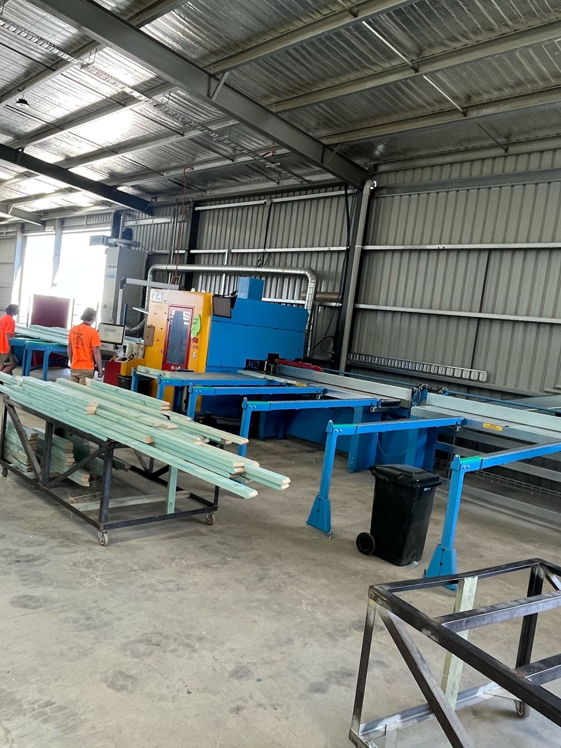 Interior view of a workshop with machinery and materials. 