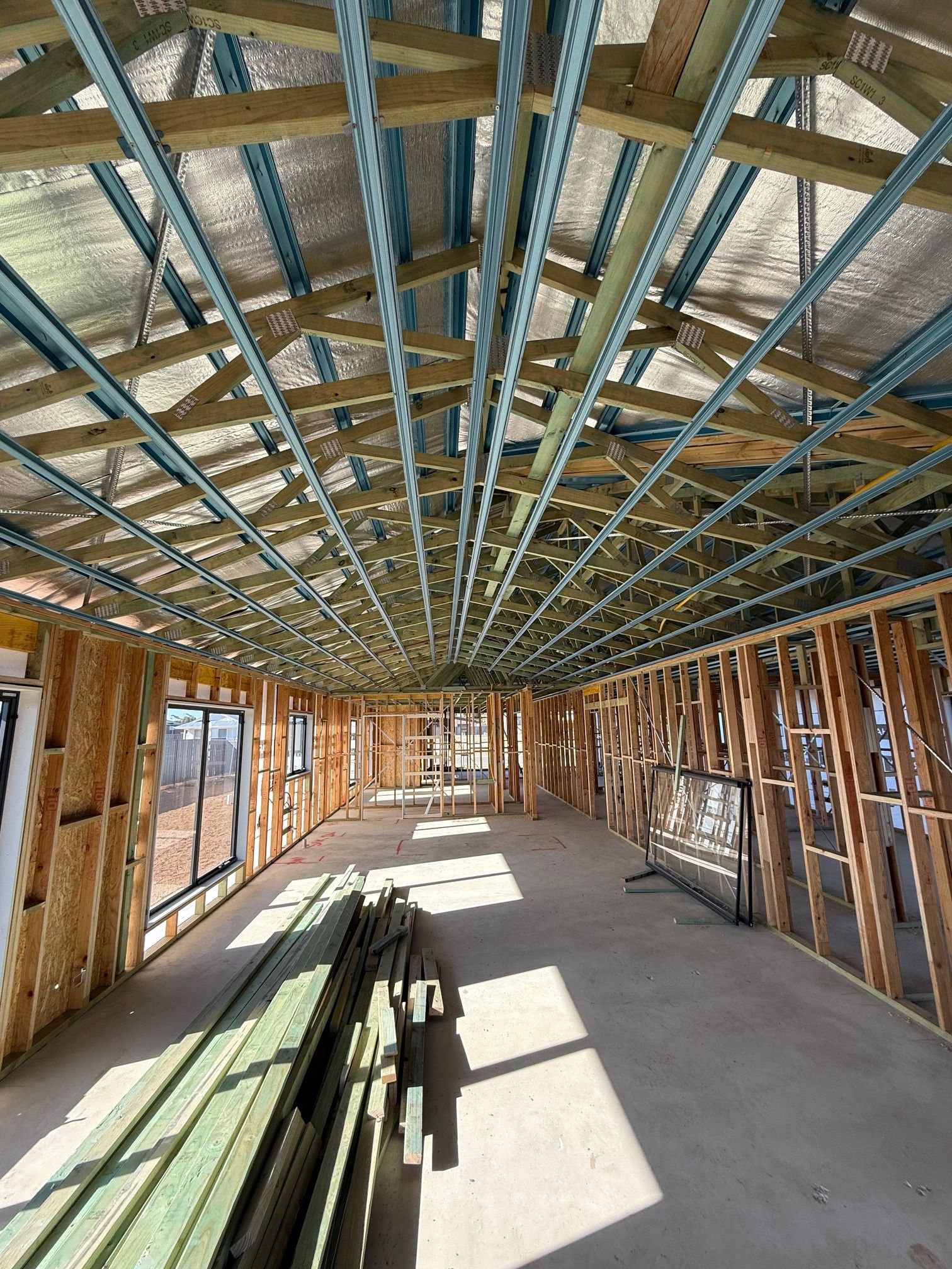The inside of a building under construction with a lot of wooden beams.