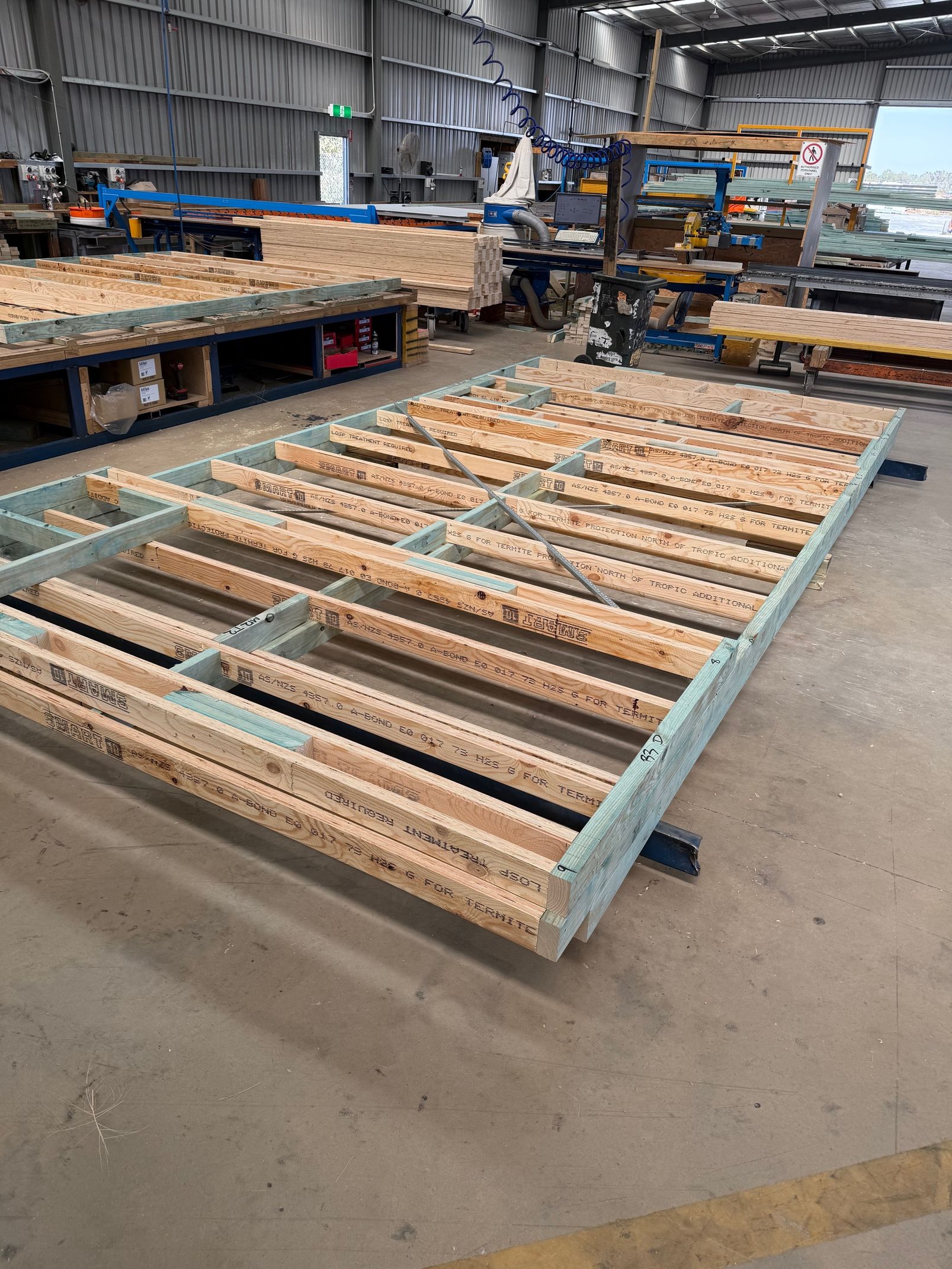 A large piece of wood is sitting on top of a concrete floor in a warehouse.