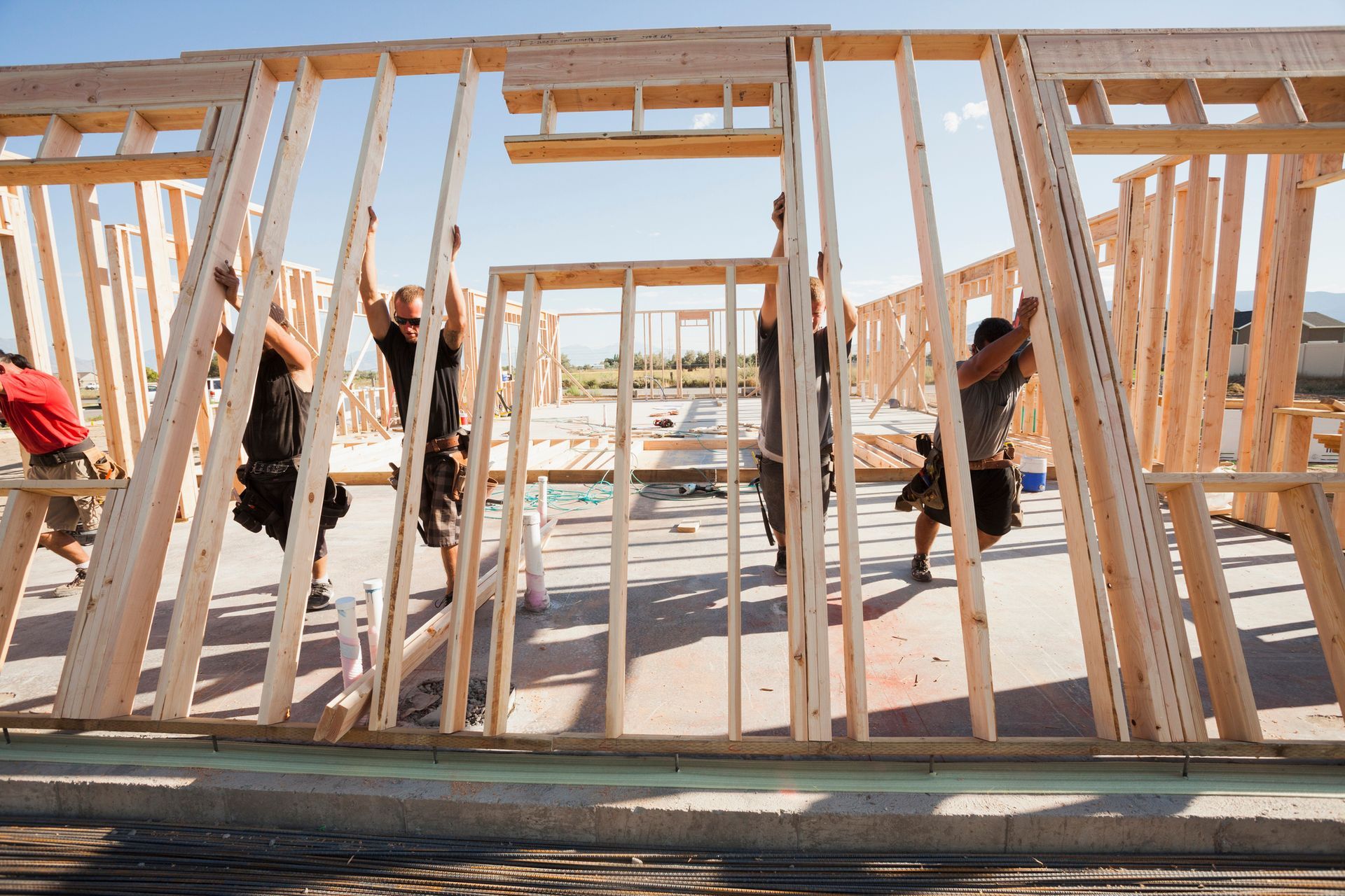 Image of workers lifting a frame on a construction site. Image of workers lifting a frame on a construction site.