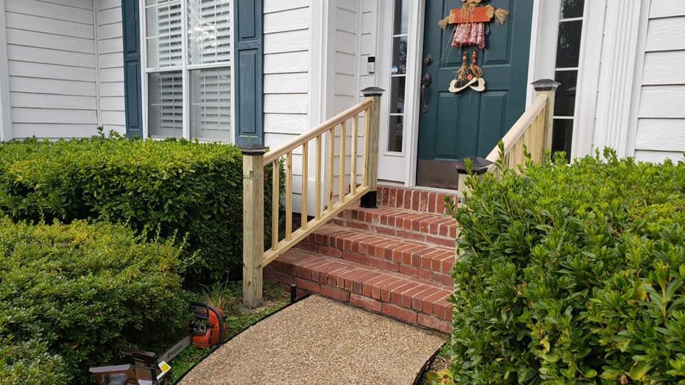 There is a wooden railing on the steps of a house.
