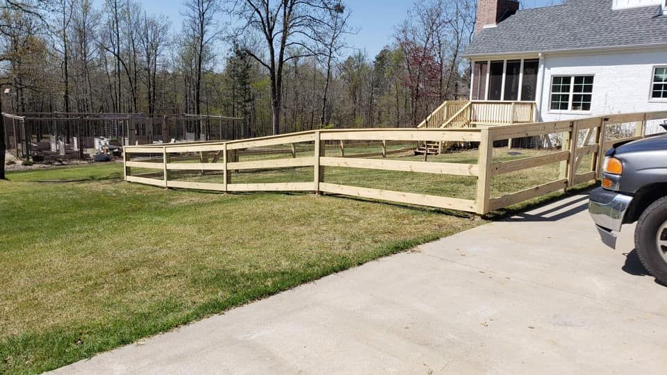 A truck is parked in front of a house with a wooden fence.