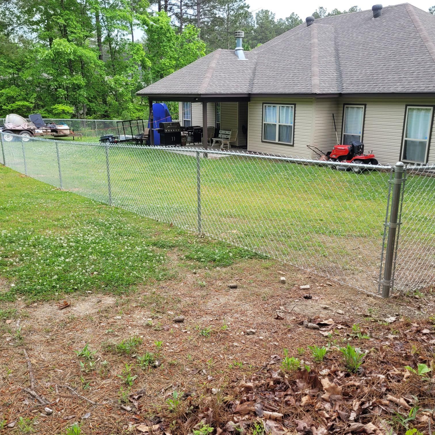 There is a chain link fence in the backyard of a house.