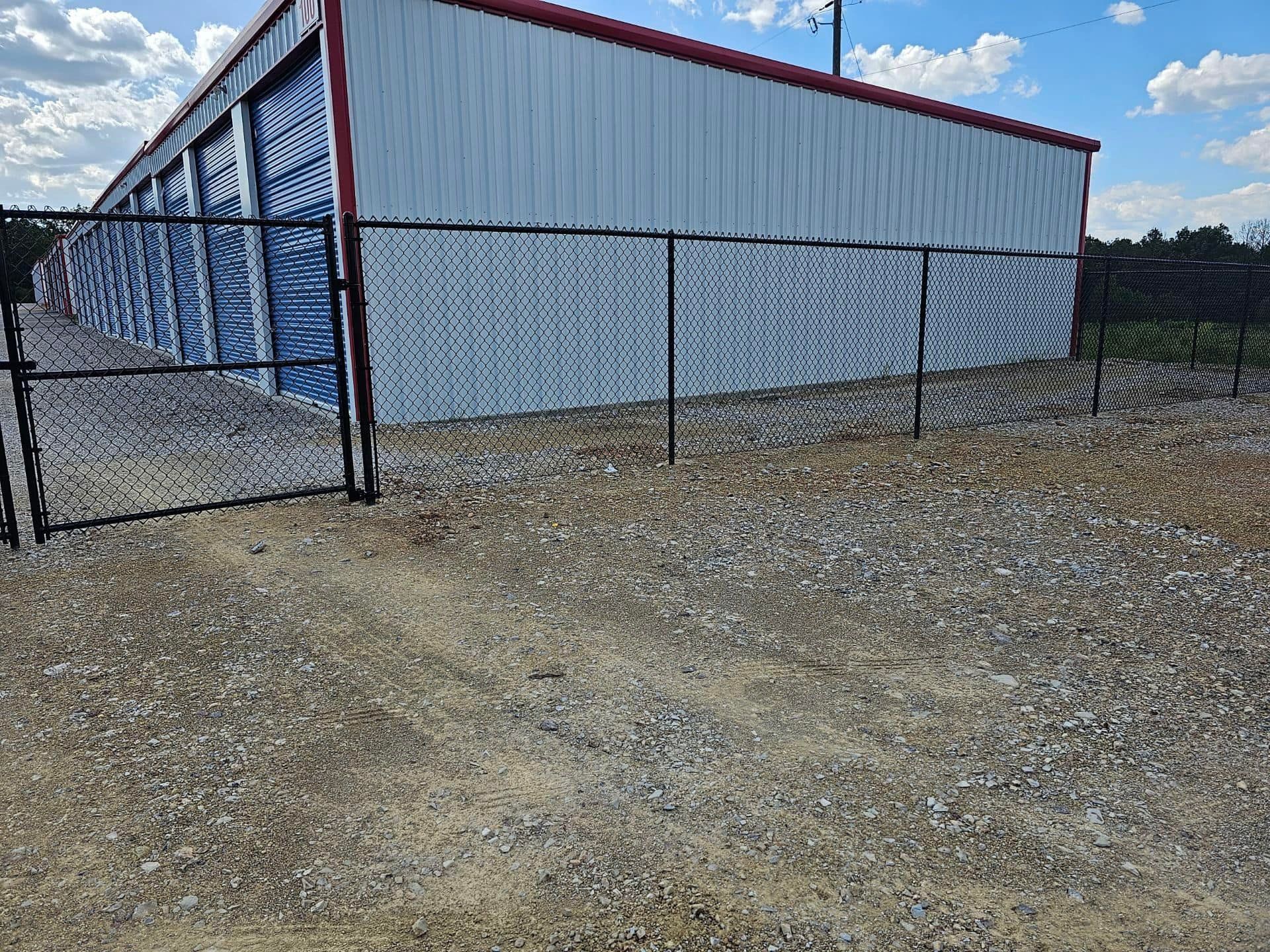 A chain link fence is surrounding a storage building.