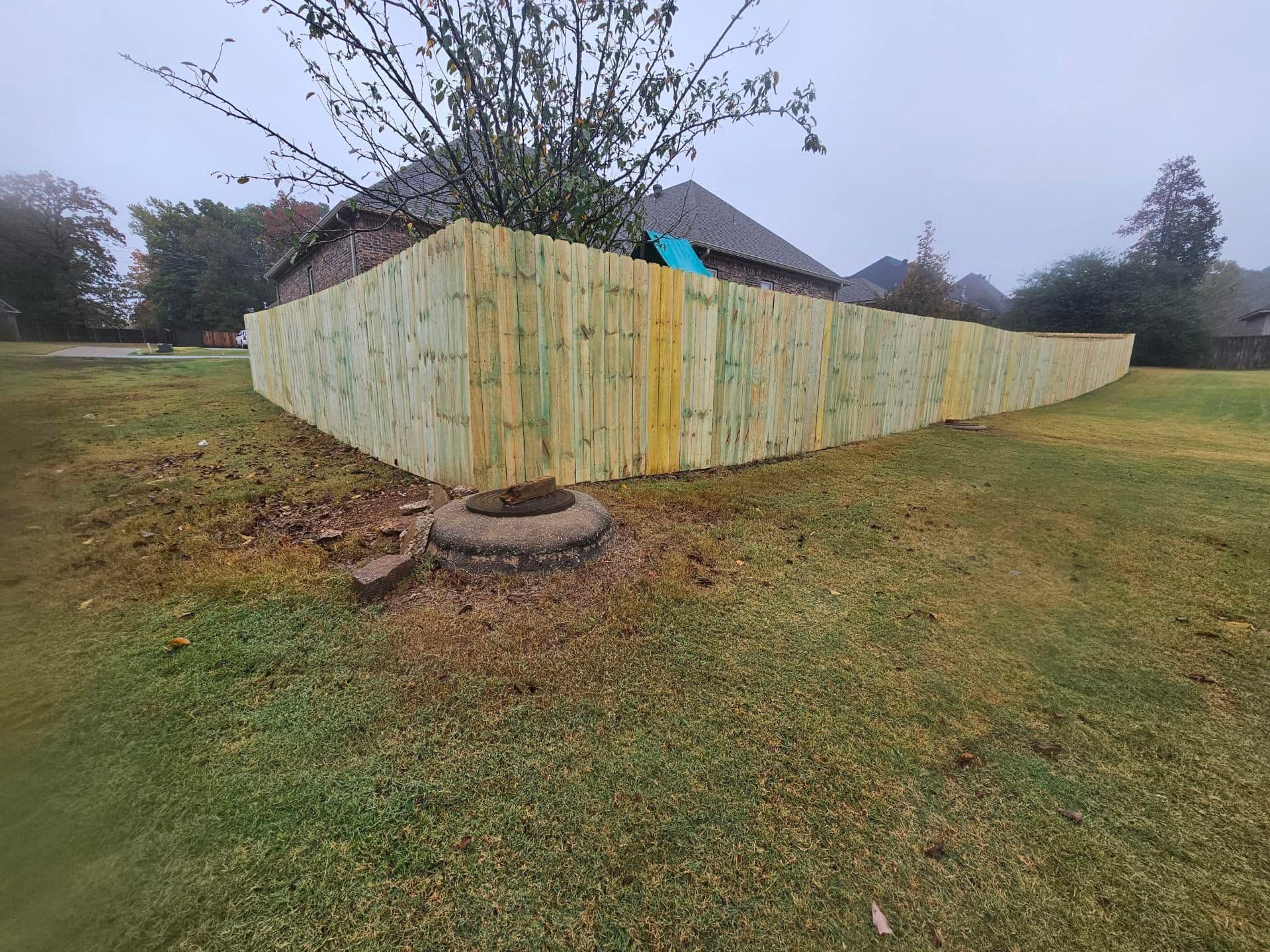 A wooden fence is sitting in the middle of a grassy field.