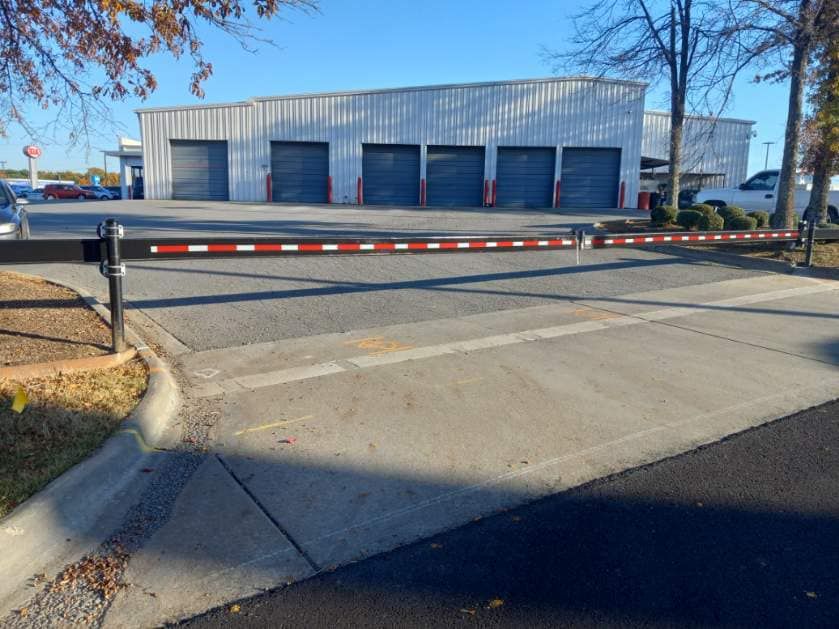 A barrier is blocking a parking lot in front of a building.