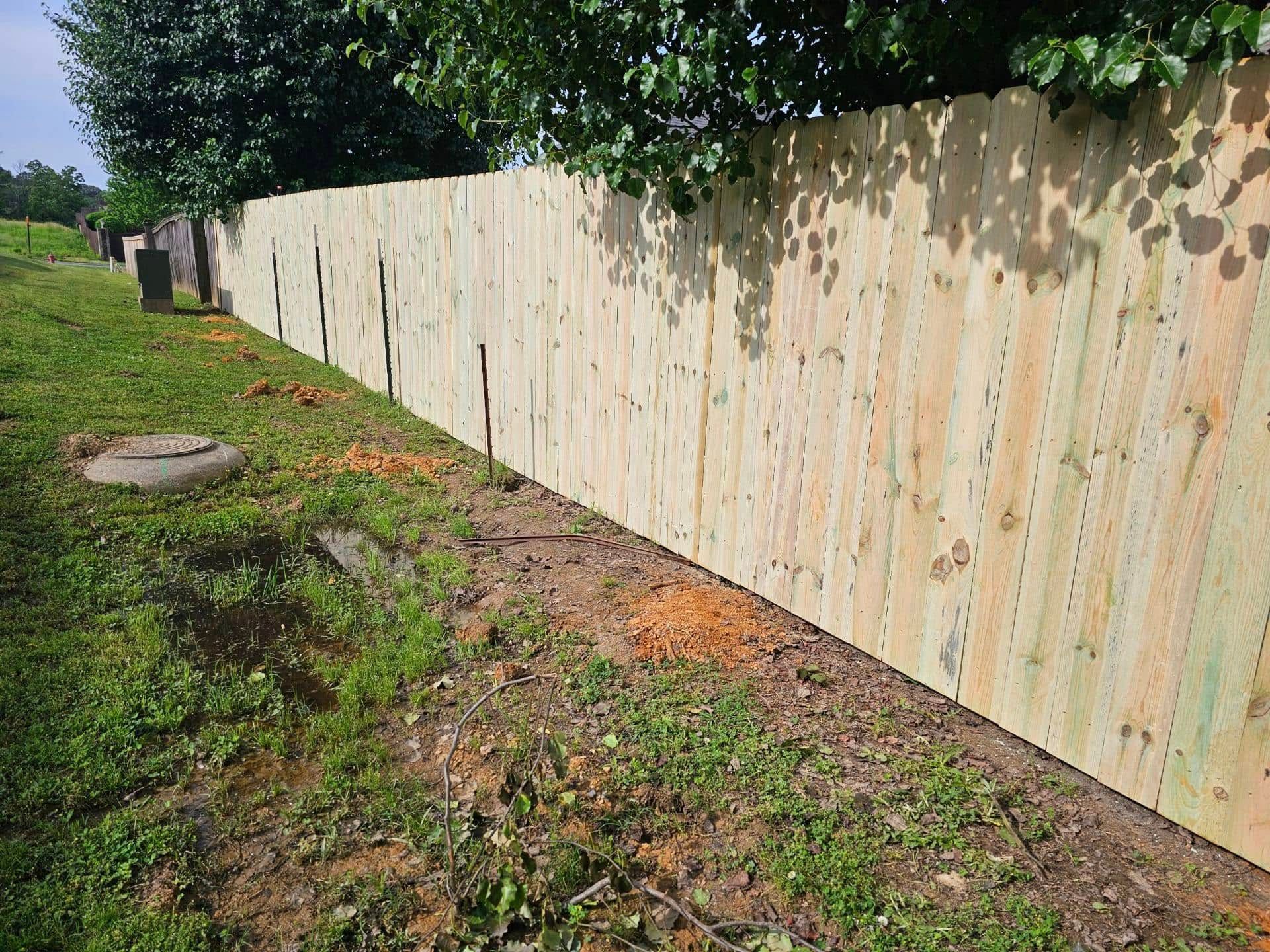 A wooden fence is sitting in the middle of a grassy field.