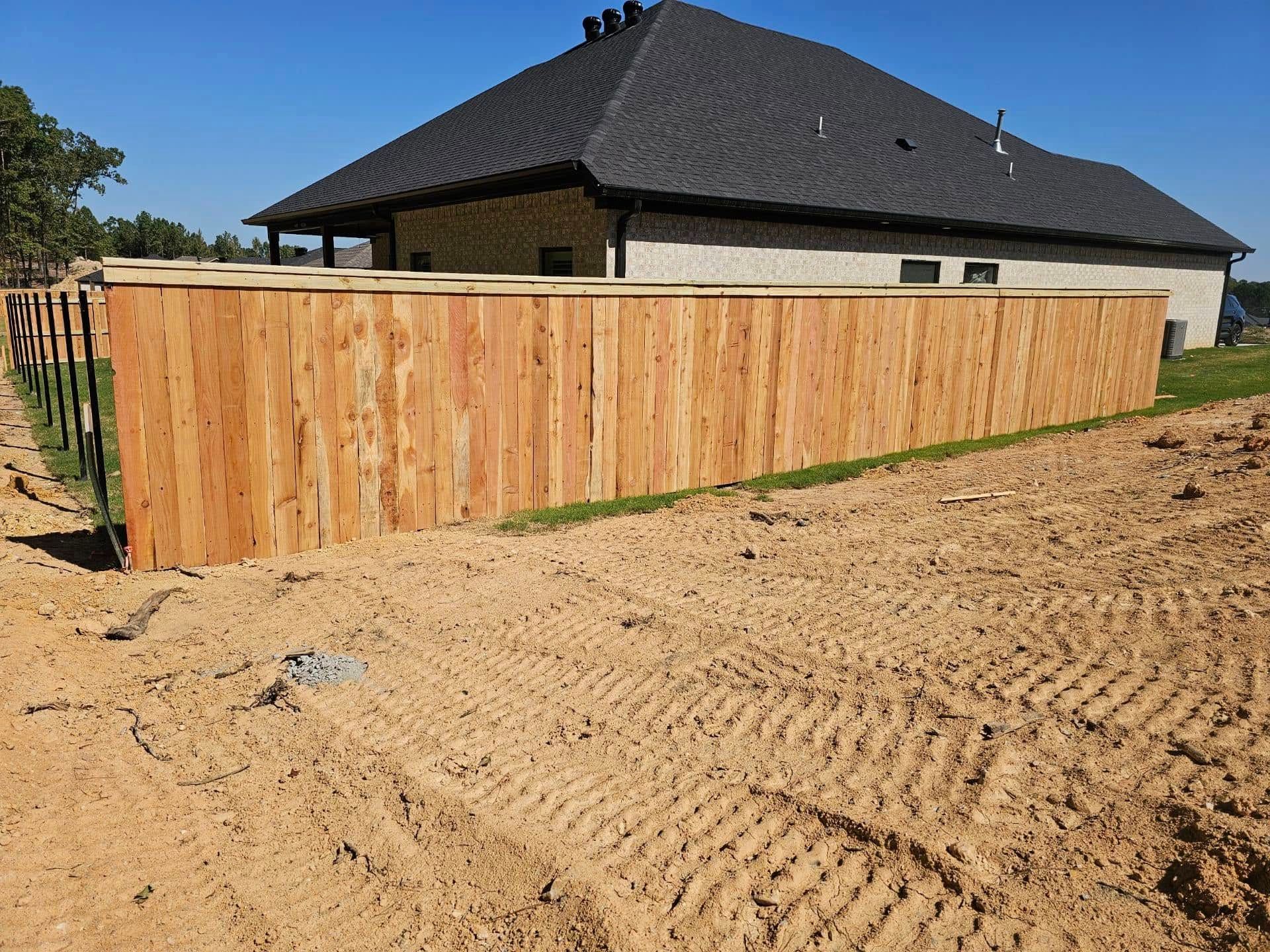 A wooden fence is being built in front of a house.