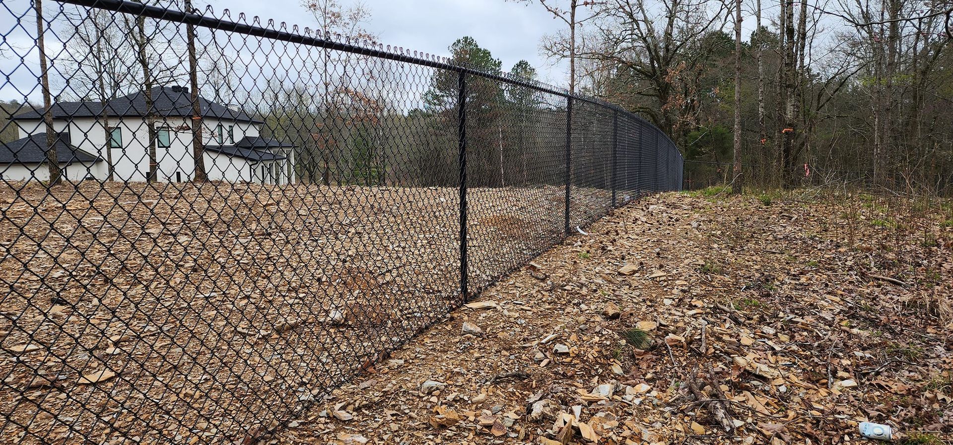 A chain link fence is surrounded by a pile of leaves.