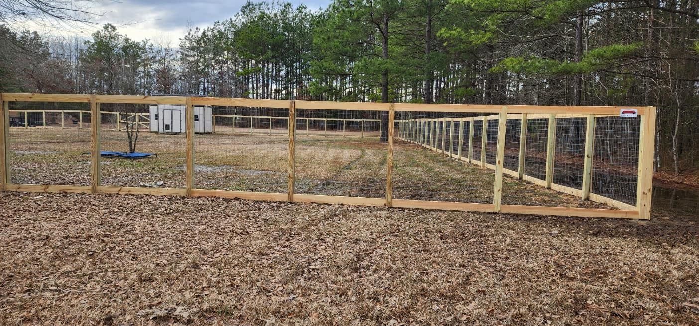 A wooden fence is sitting on top of a pile of leaves in a field.