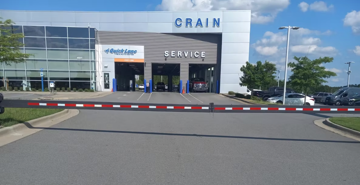 A car dealership with a red and white barrier in front of it