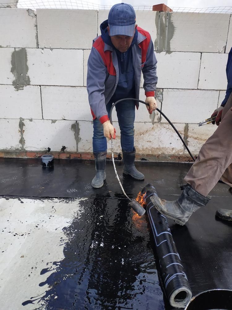 A Man Is Working on A Roof with A Torch — Formosa Building And Renovations in Kensington, QLD
