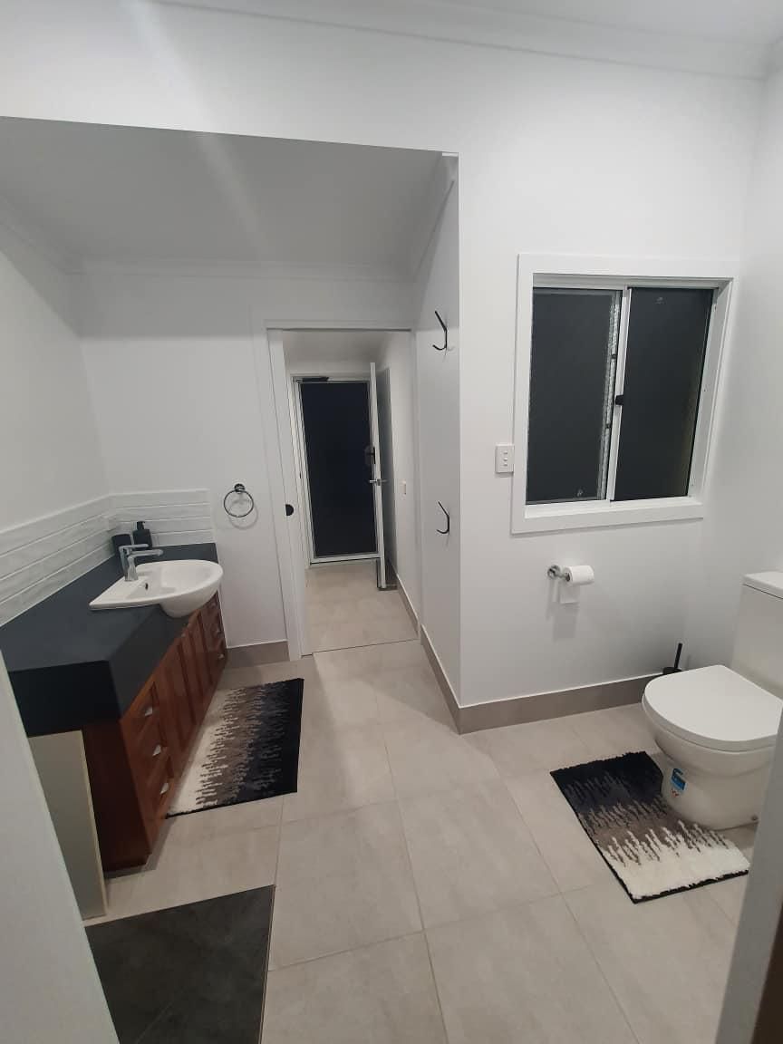 A Bathroom with A Toilet, Sink, and Window — Formosa Building And Renovations in Baffle Creek, QLD