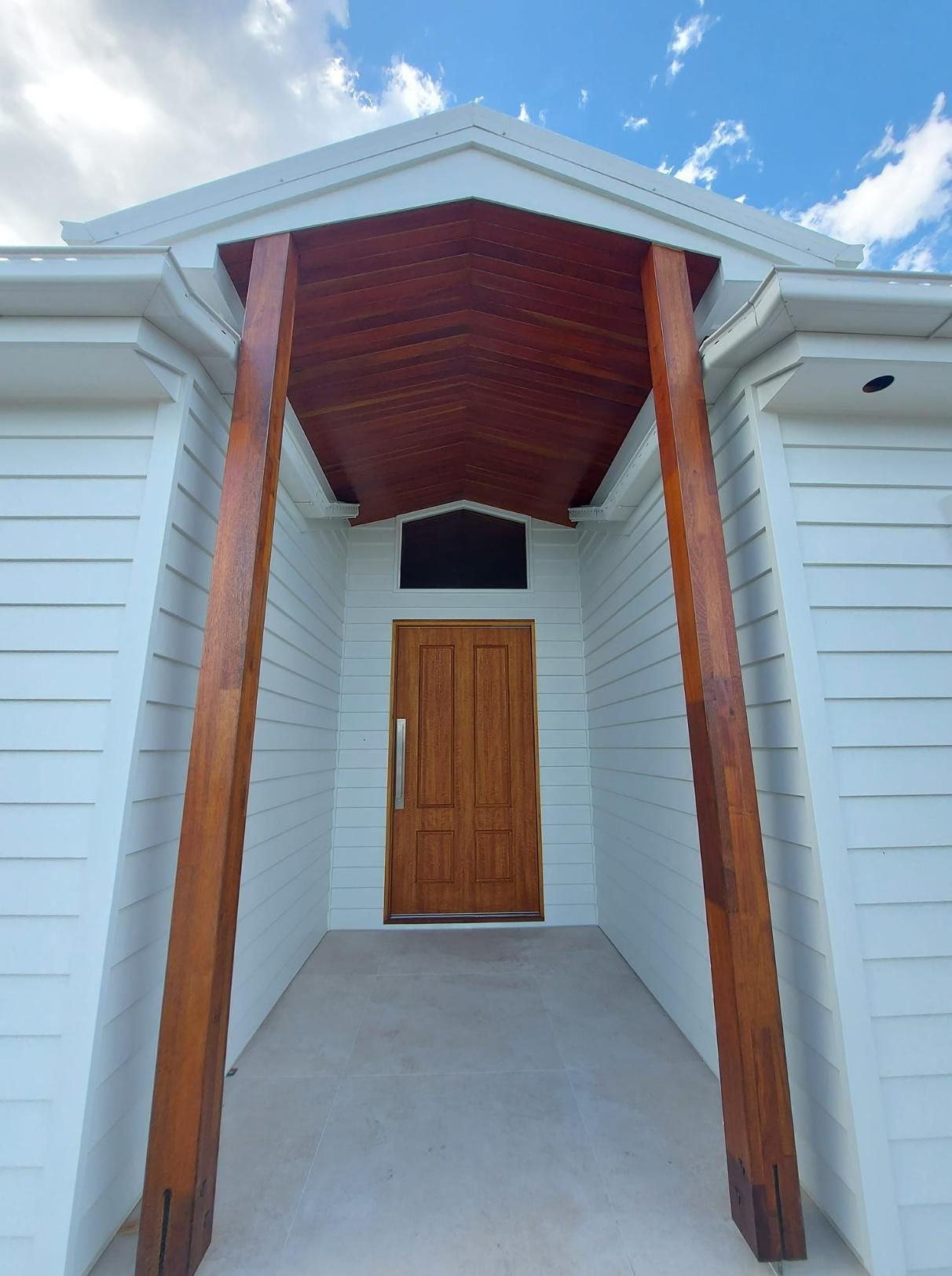 A White House with A Wooden Door and Pillars — Formosa Building And Renovations in South Kolan, QLD
