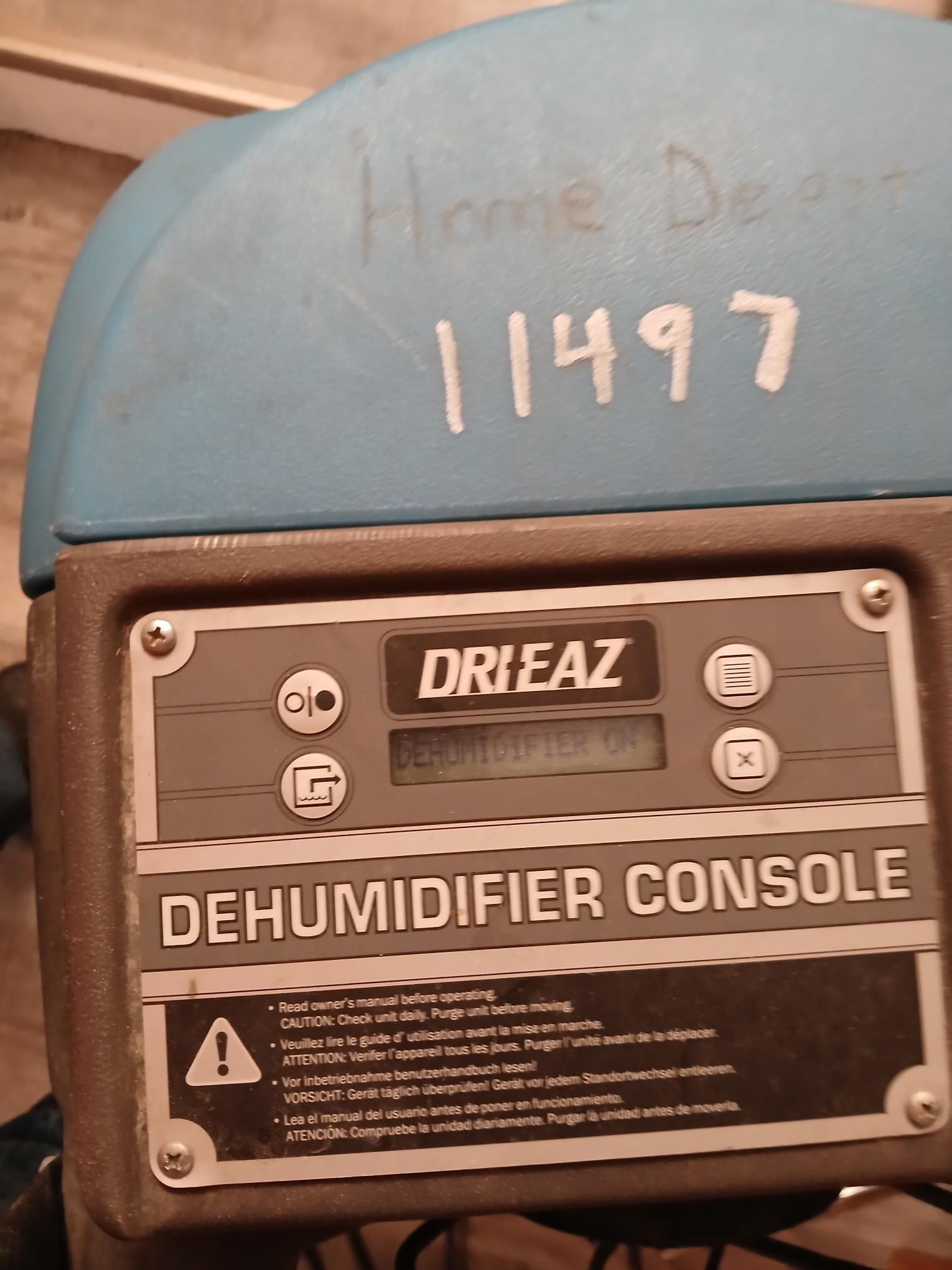 Blue and gray Dri-Eaz dehumidifier console with a digital display and warning text.