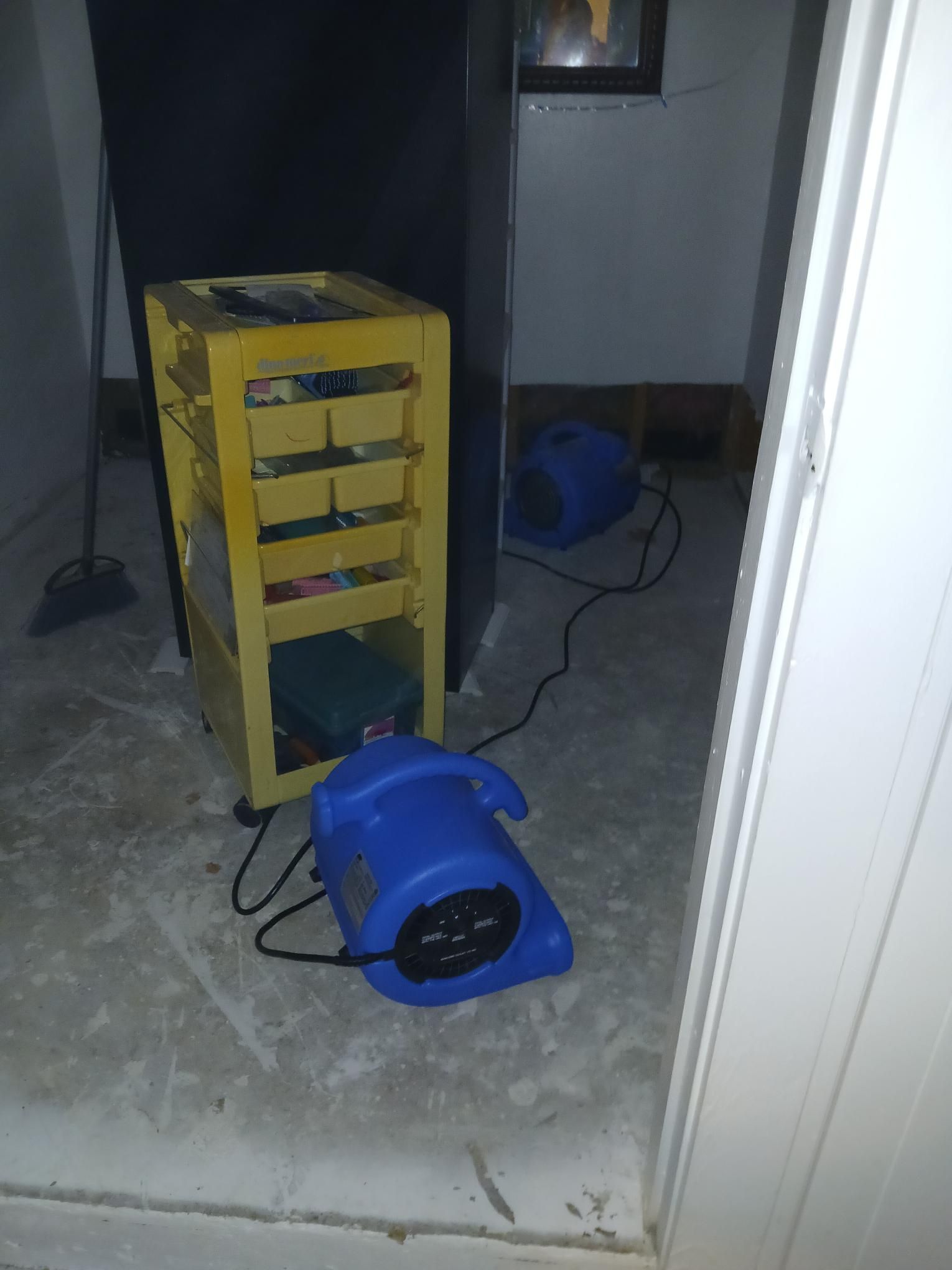 Yellow cart and two blue fans in a room, drying the floor.