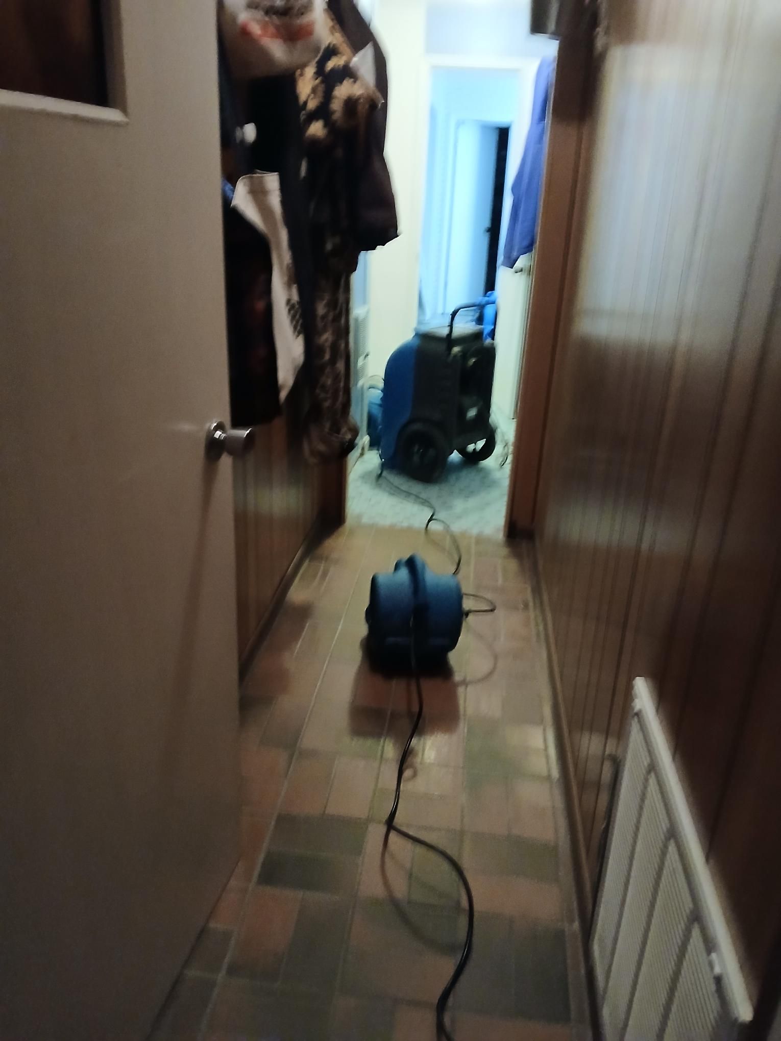 Narrow hallway with two blue air movers.