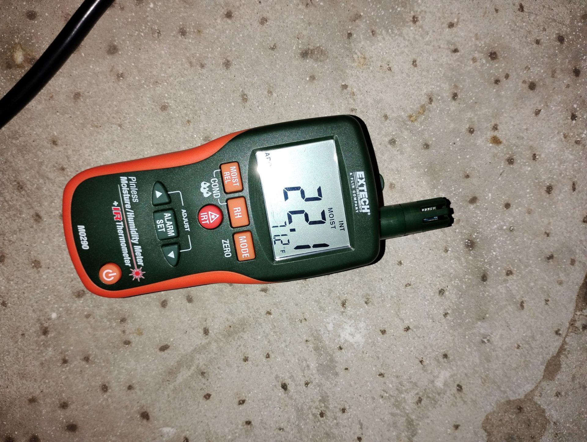 A moisture meter displaying the numbers 