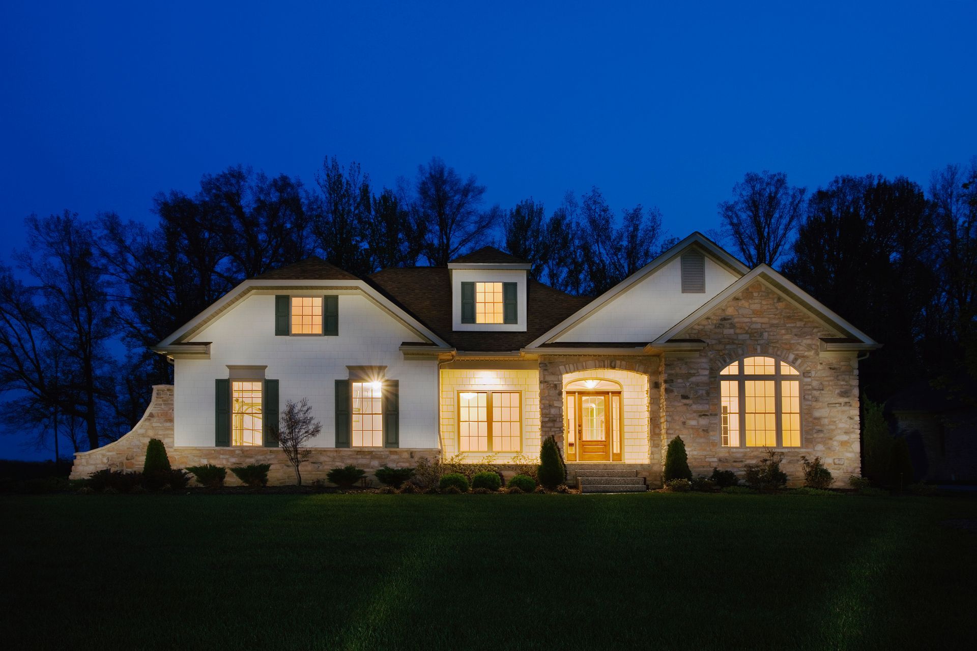 A hotel room with a couch , desk , television and refrigerator.