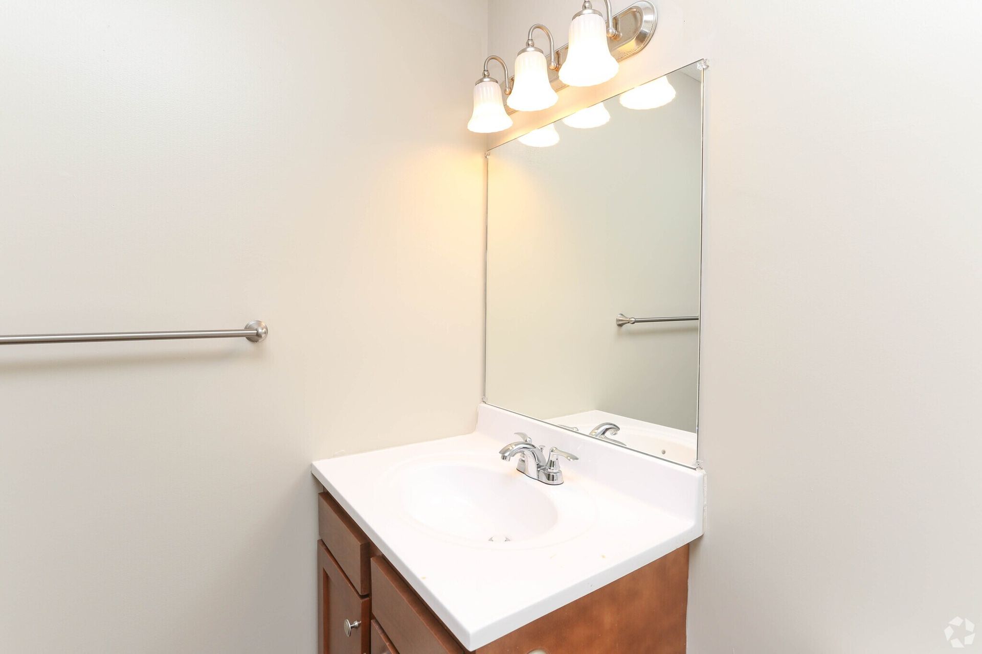 A bathroom with a sink , mirror and towel rack.