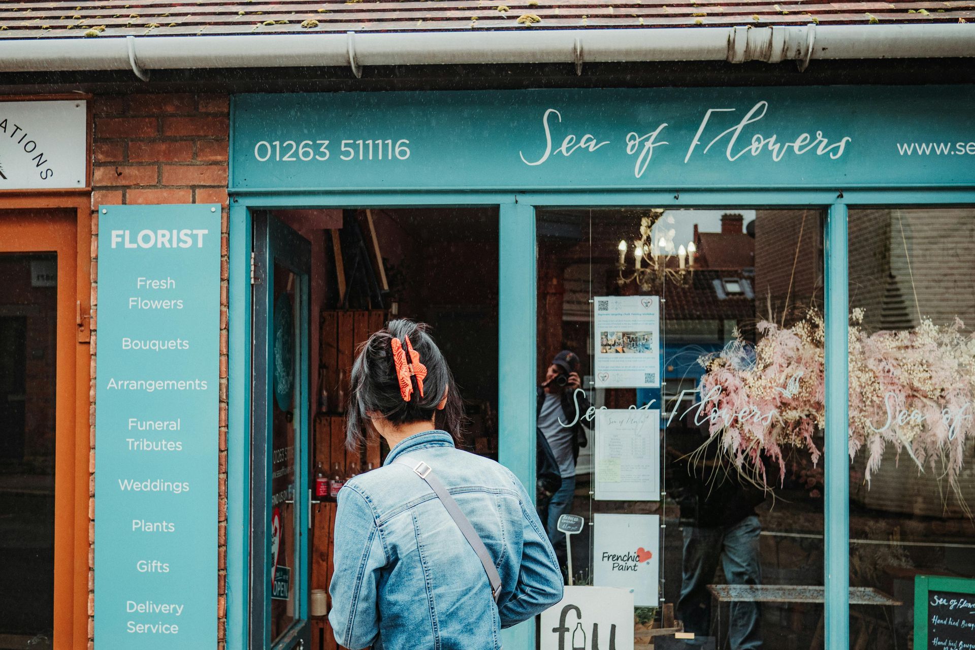 Woman entering a flower shop, 