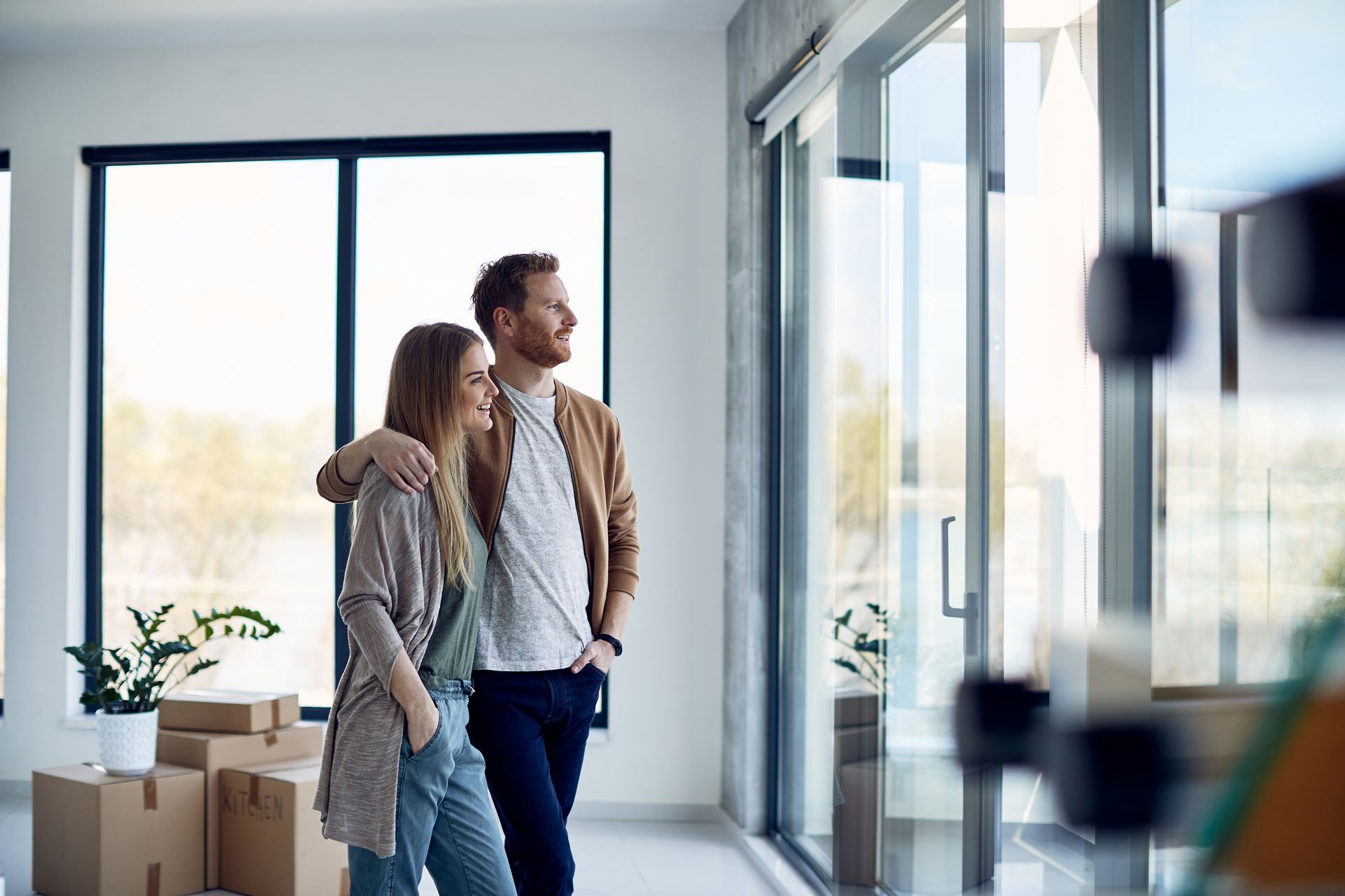 A man and a woman are standing in a room with cardboard boxes.