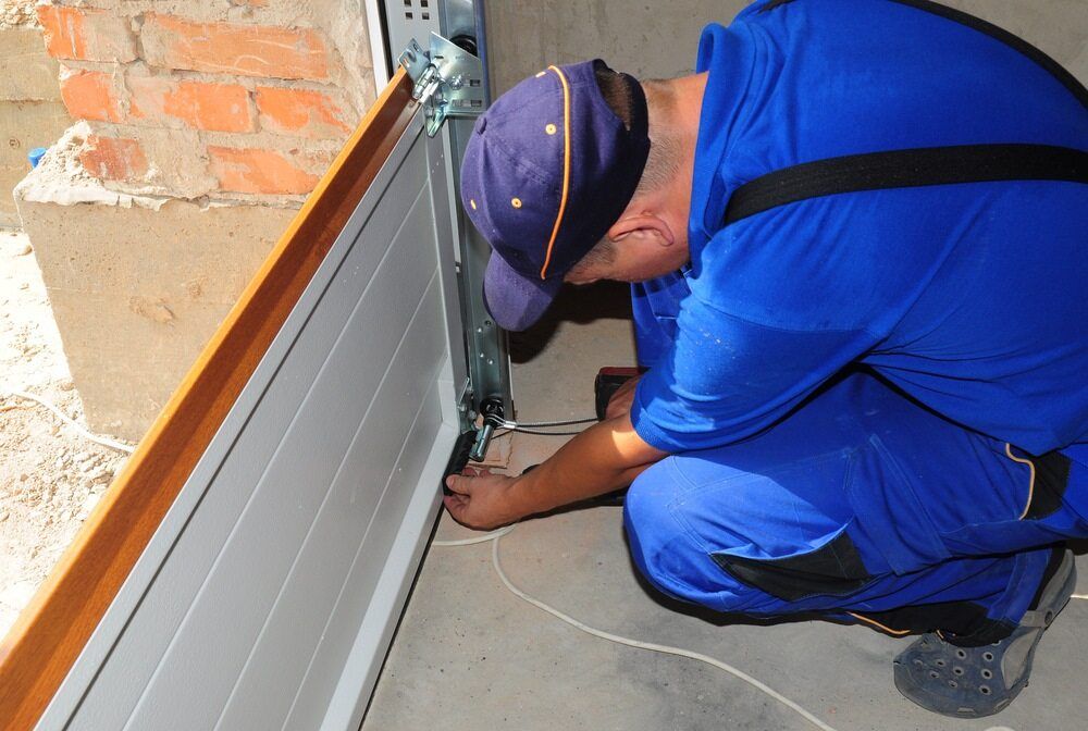 Man Repairing a Garage Door — Duncan's Doors In Oakey, QLD