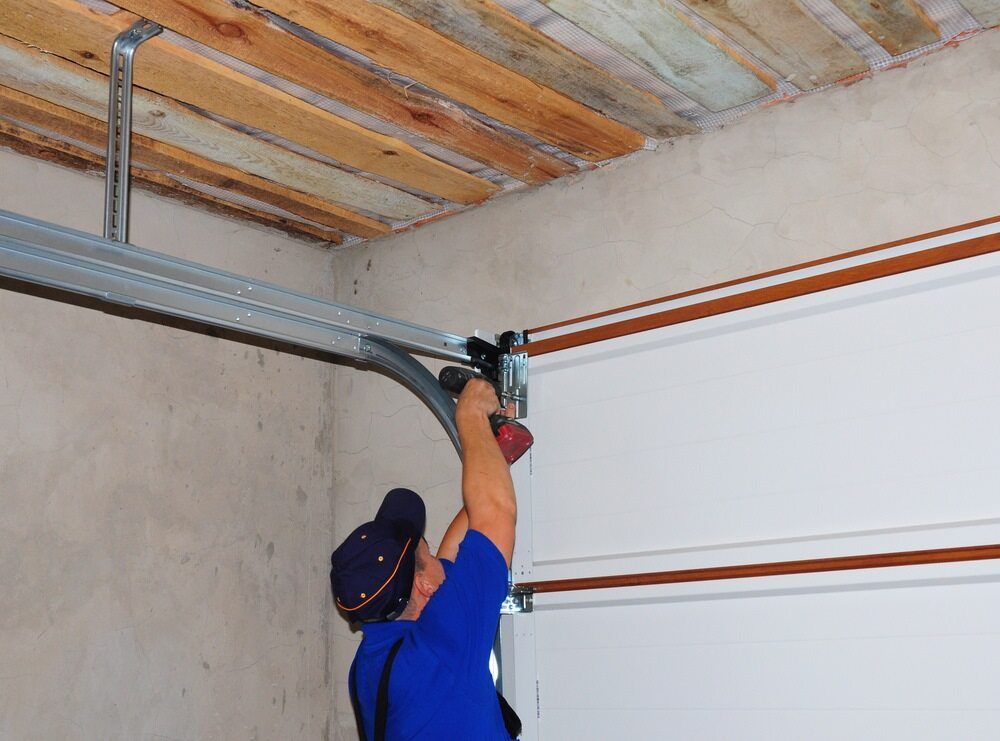A Person Installs a Garage Door Opener Track in a Garage — Duncan's Doors In Warwick, QLD