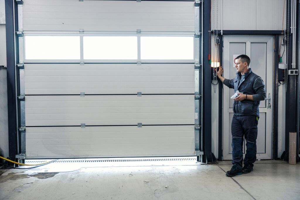 Man Operates Industrial Garage Door in a Warehouse — Duncan's Doors In Bell, QLD
