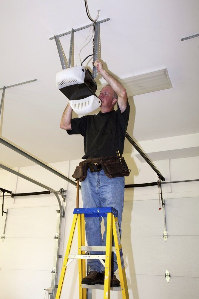 Man on a Stepladder Installing a Garage Door Opener — Duncan's Doors In Gatton, QLD