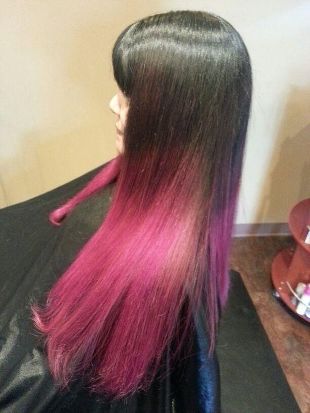 Long straight black hair with bright pink ombré ends, shown from the side in a salon chair.