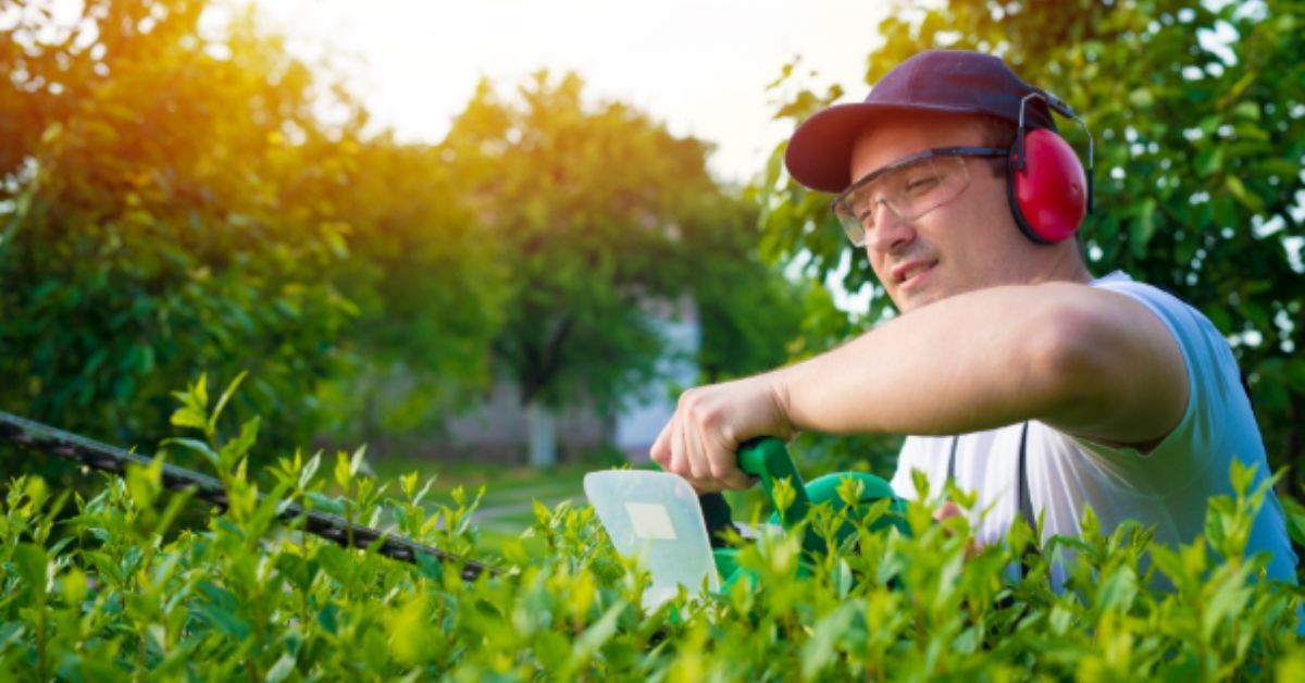 Technician applying lawn fertilization treatment in Parkville MO yard – Lawnscape Specialist
