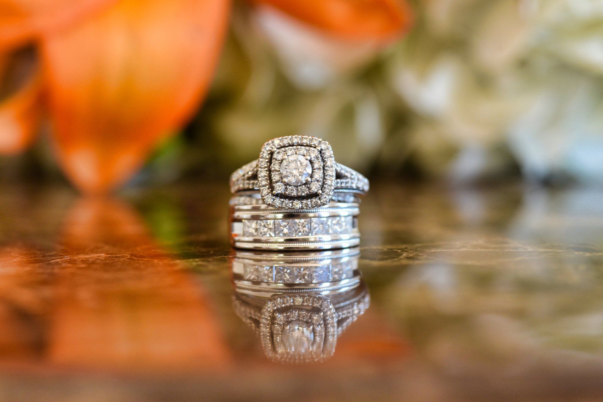 a close up of a wedding ring and engagement ring on a table .