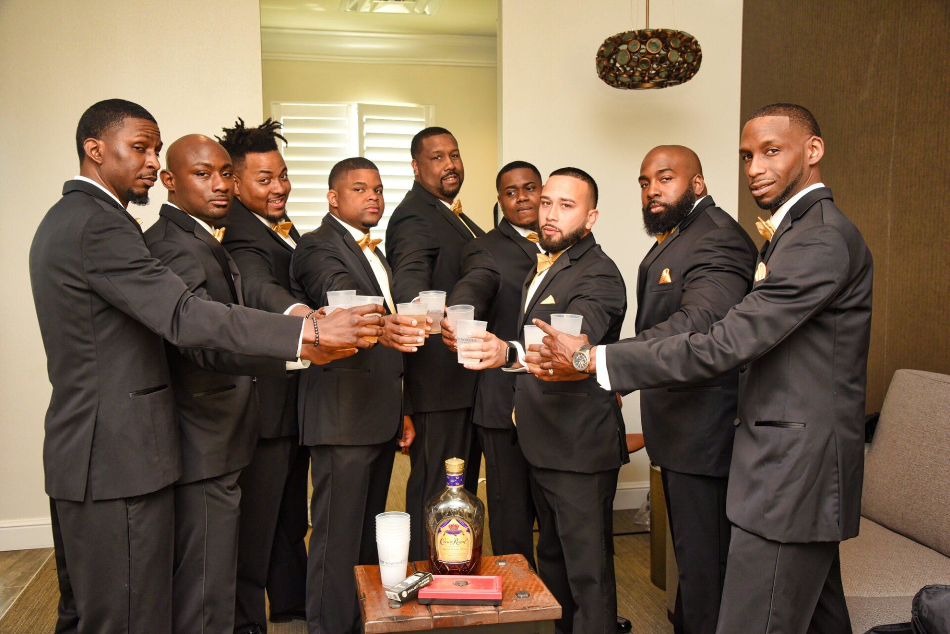 a group of men in suits are toasting with drinks .