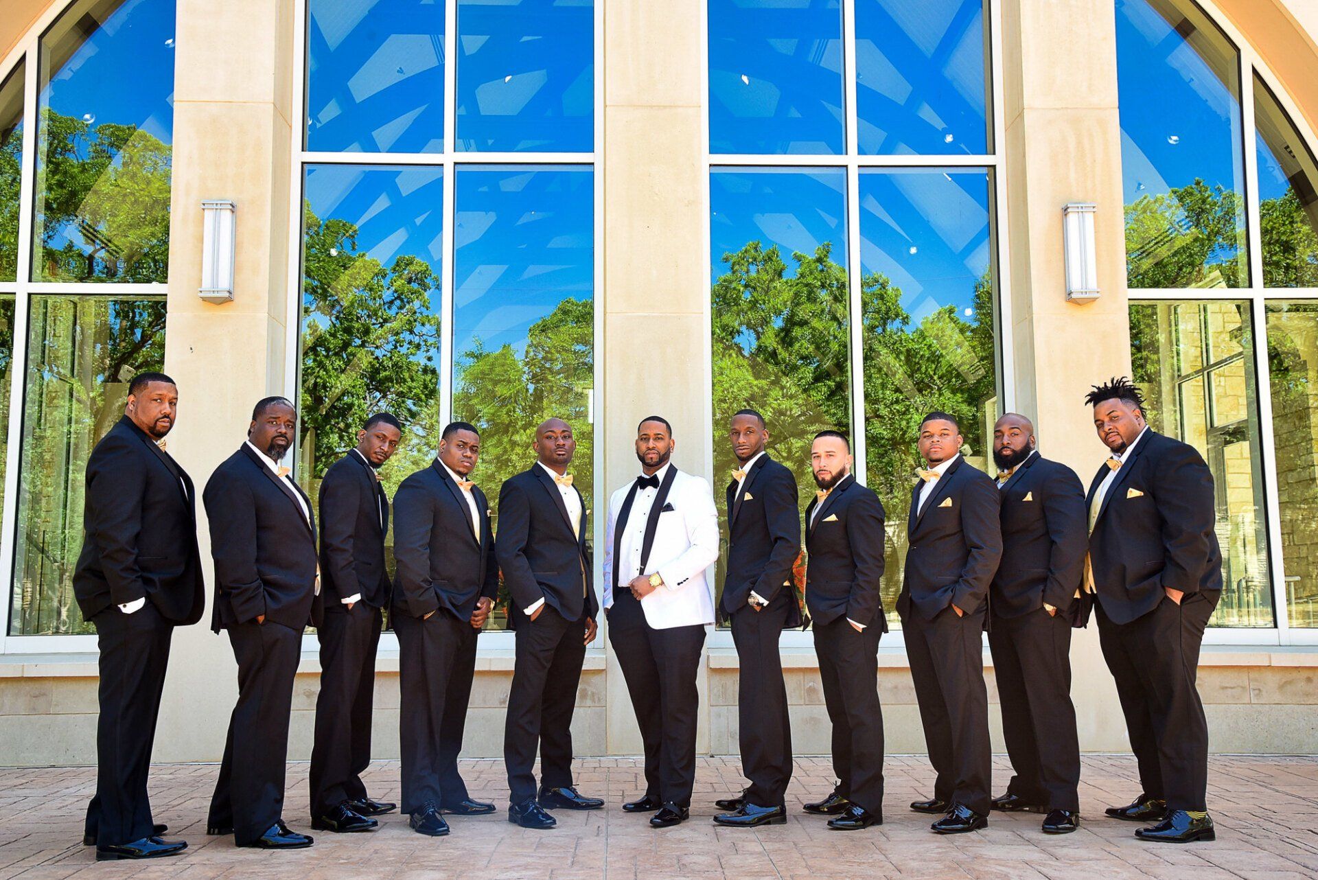 a group of men in suits are standing in front of a building .