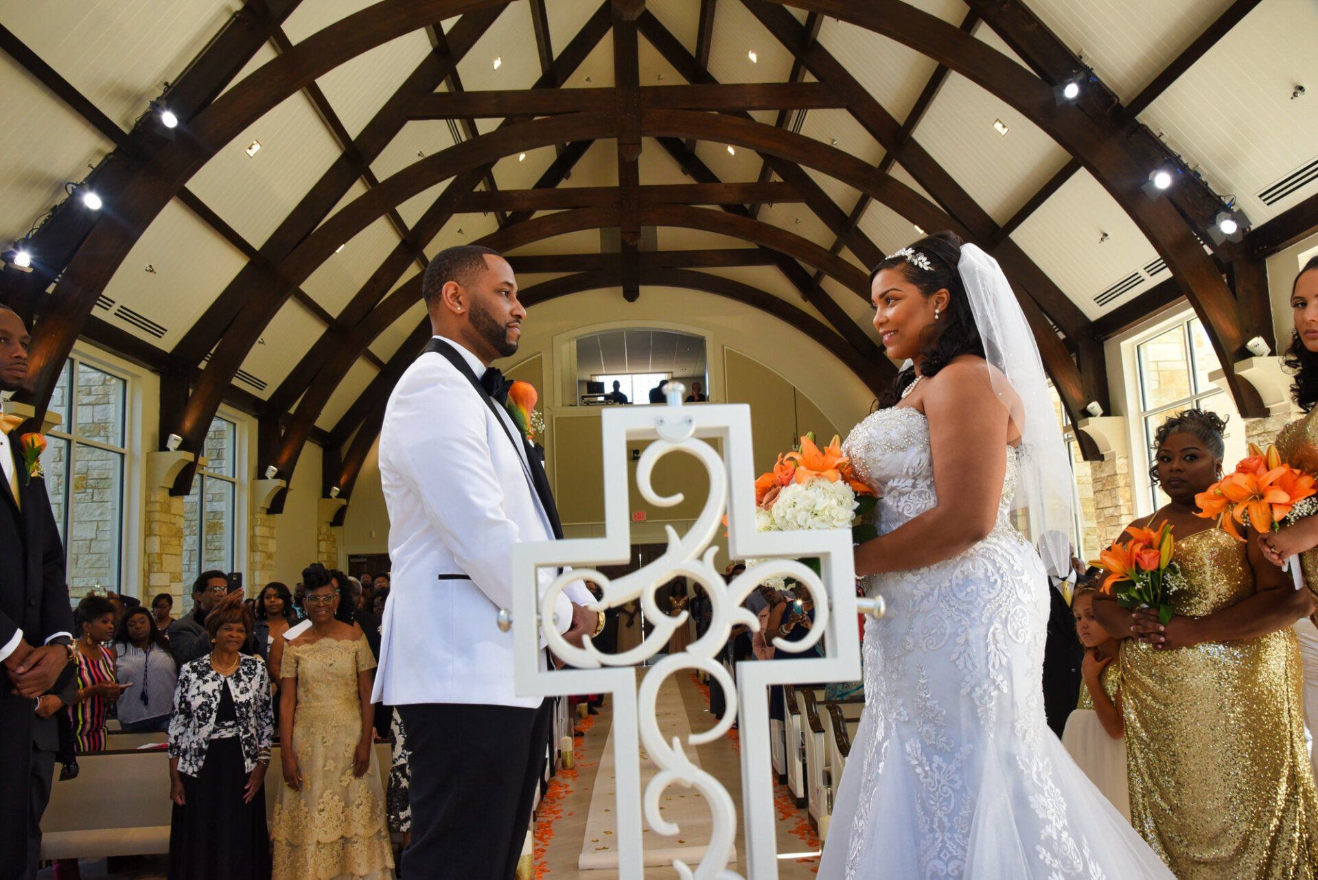 a bride and groom are holding hands during their wedding ceremony in a church .