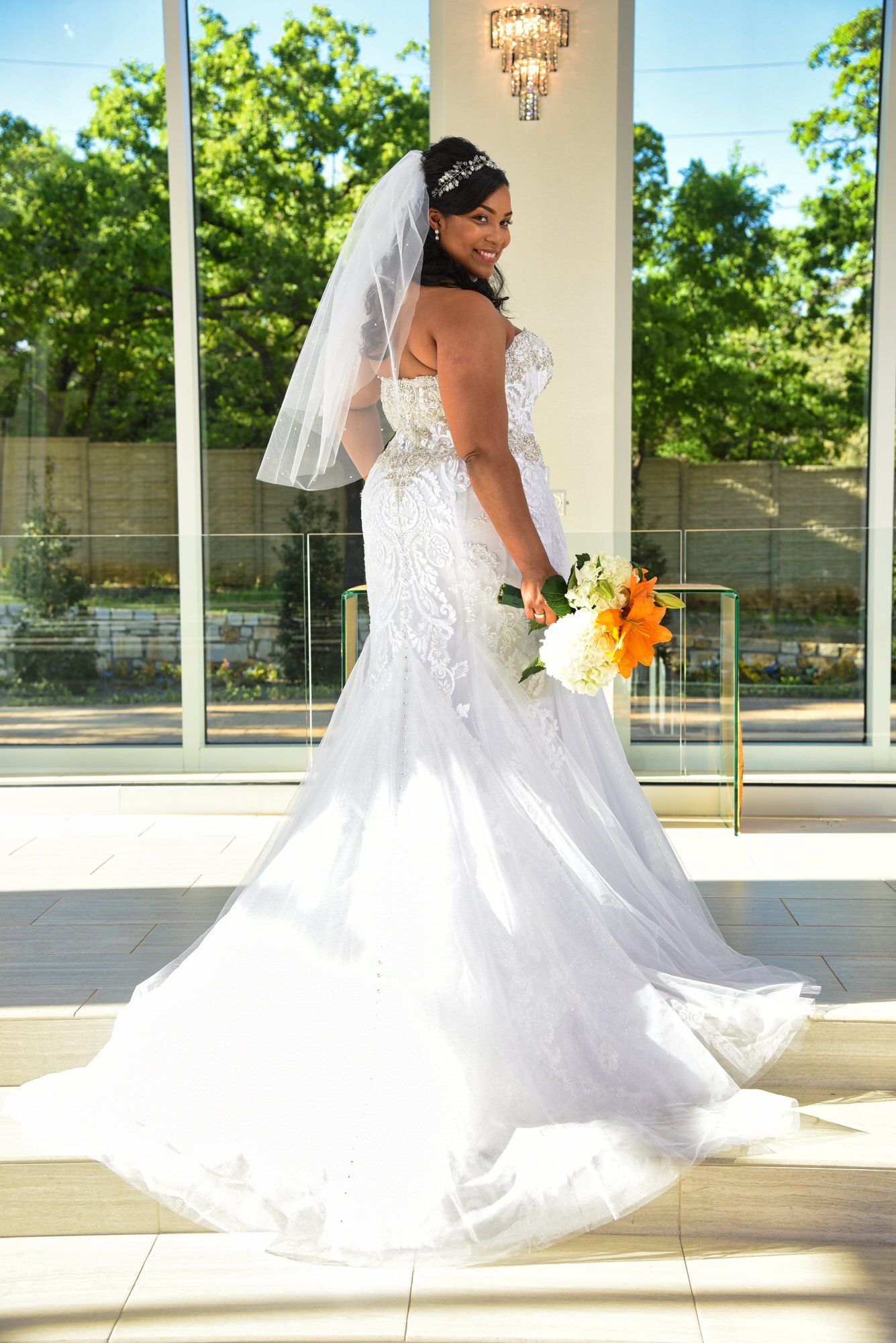 a woman in a wedding dress is holding a bouquet of flowers .