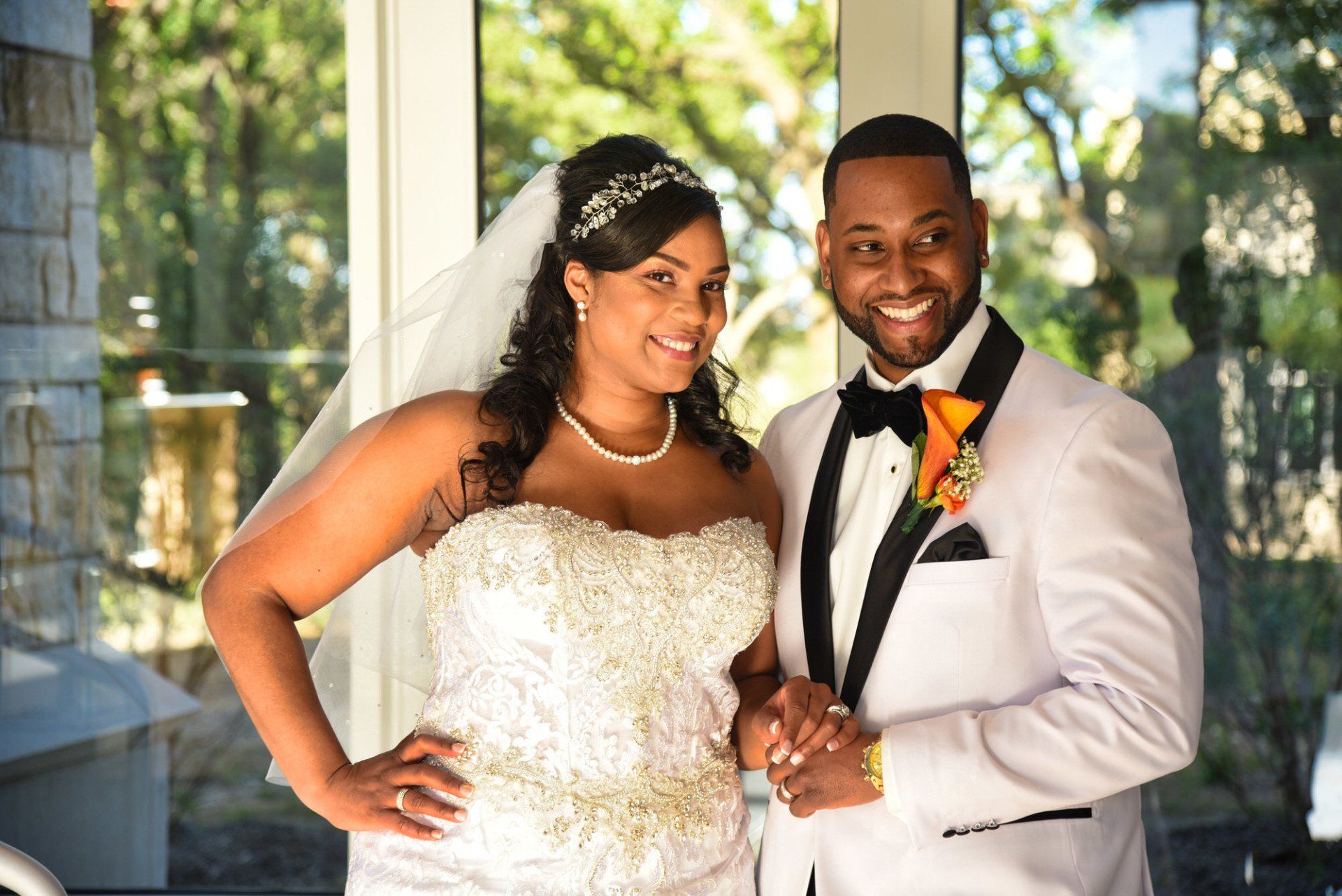 a bride and groom are posing for a picture in front of a window .
