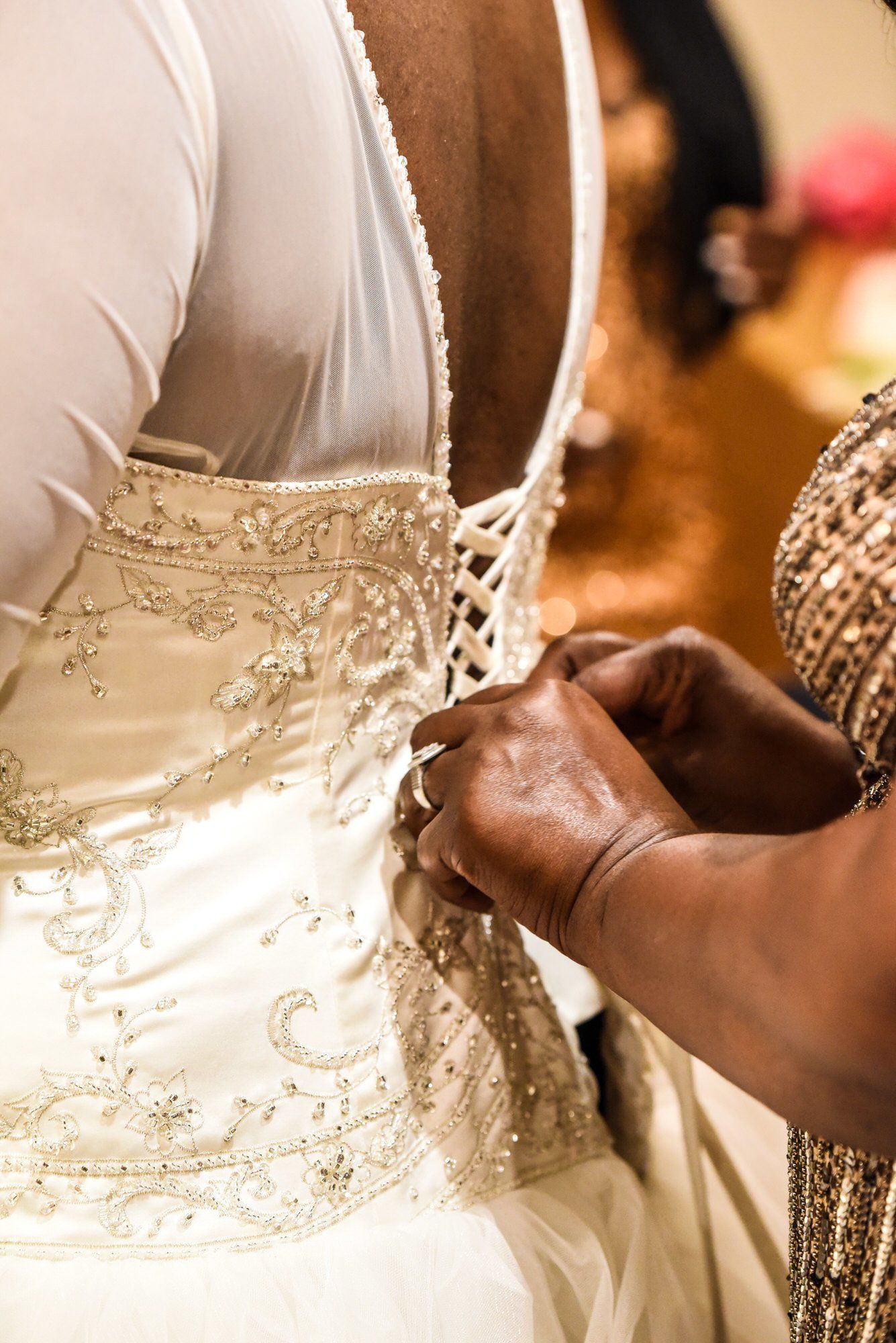 a woman is helping a woman with her wedding dress .