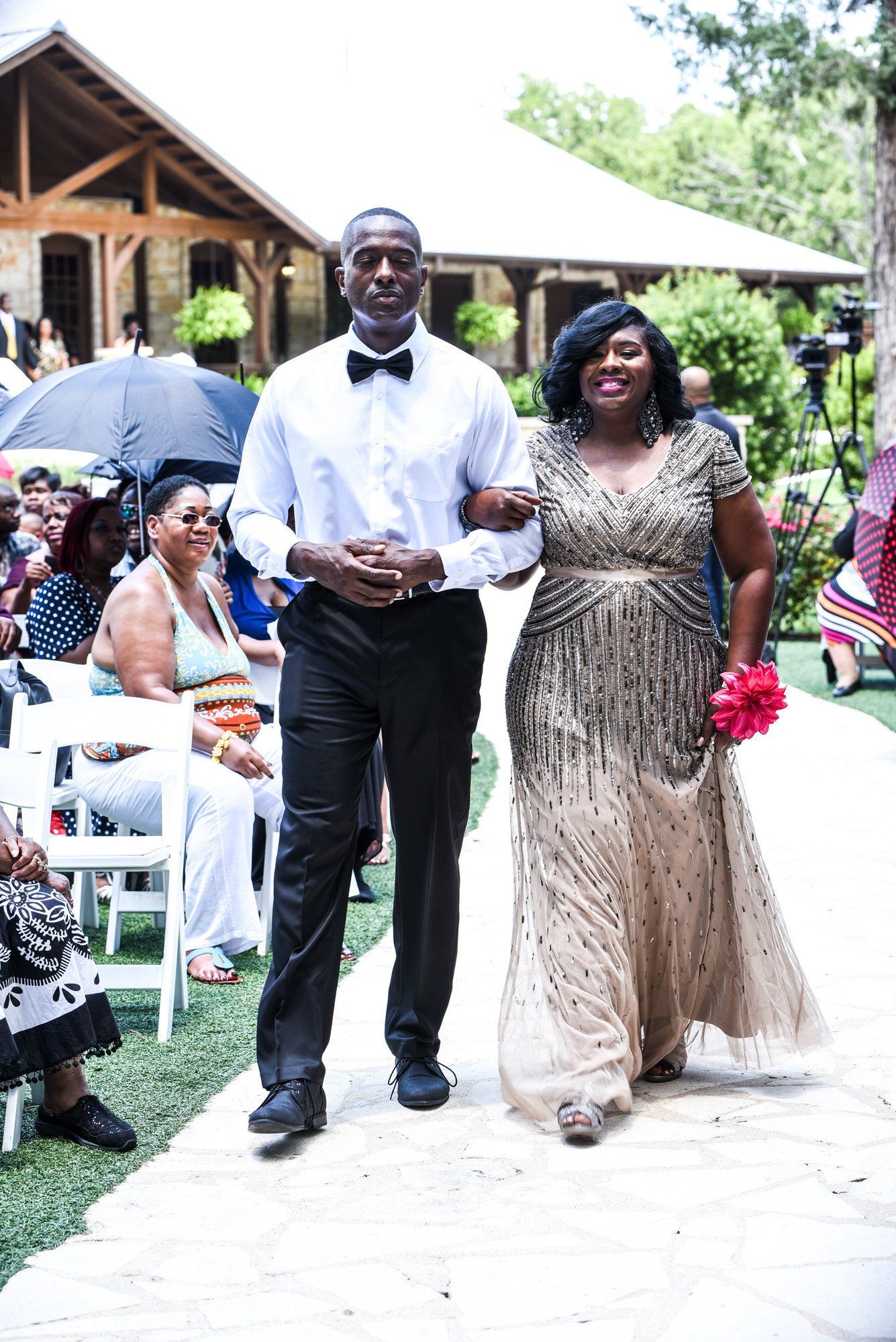 a man and a woman are walking down the aisle at a wedding .