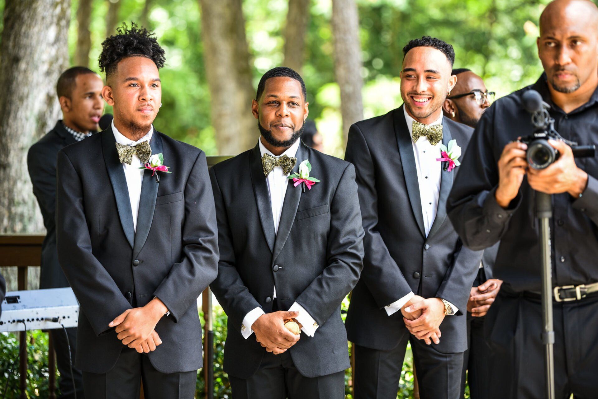 a group of men in suits and bow ties are standing next to each other .