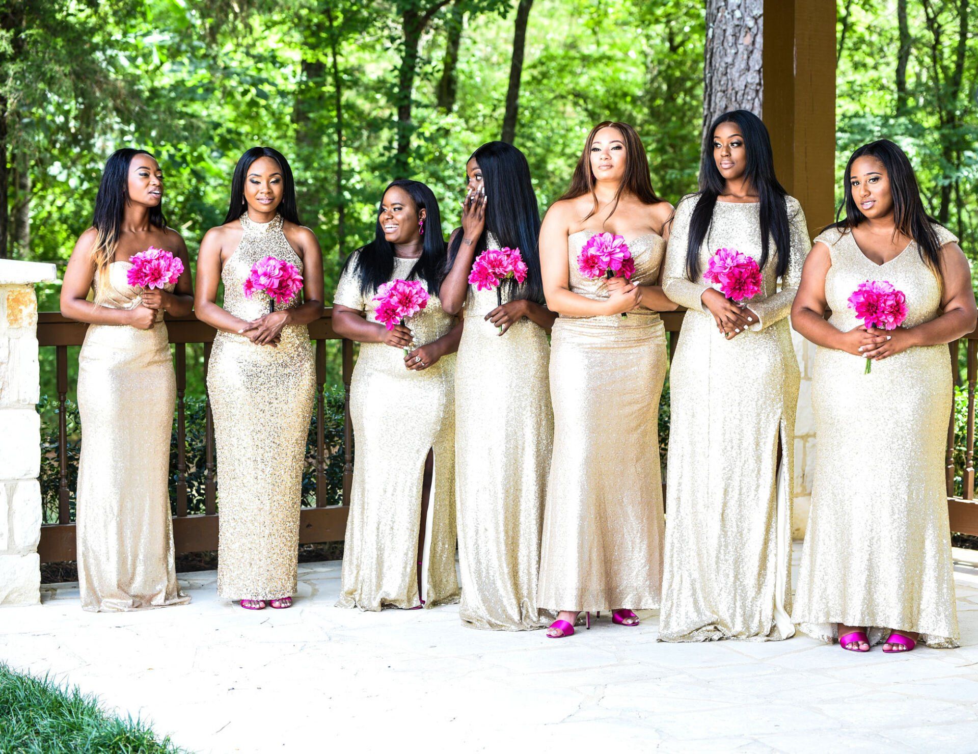 a group of bridesmaids are standing next to each other holding bouquets of pink flowers .