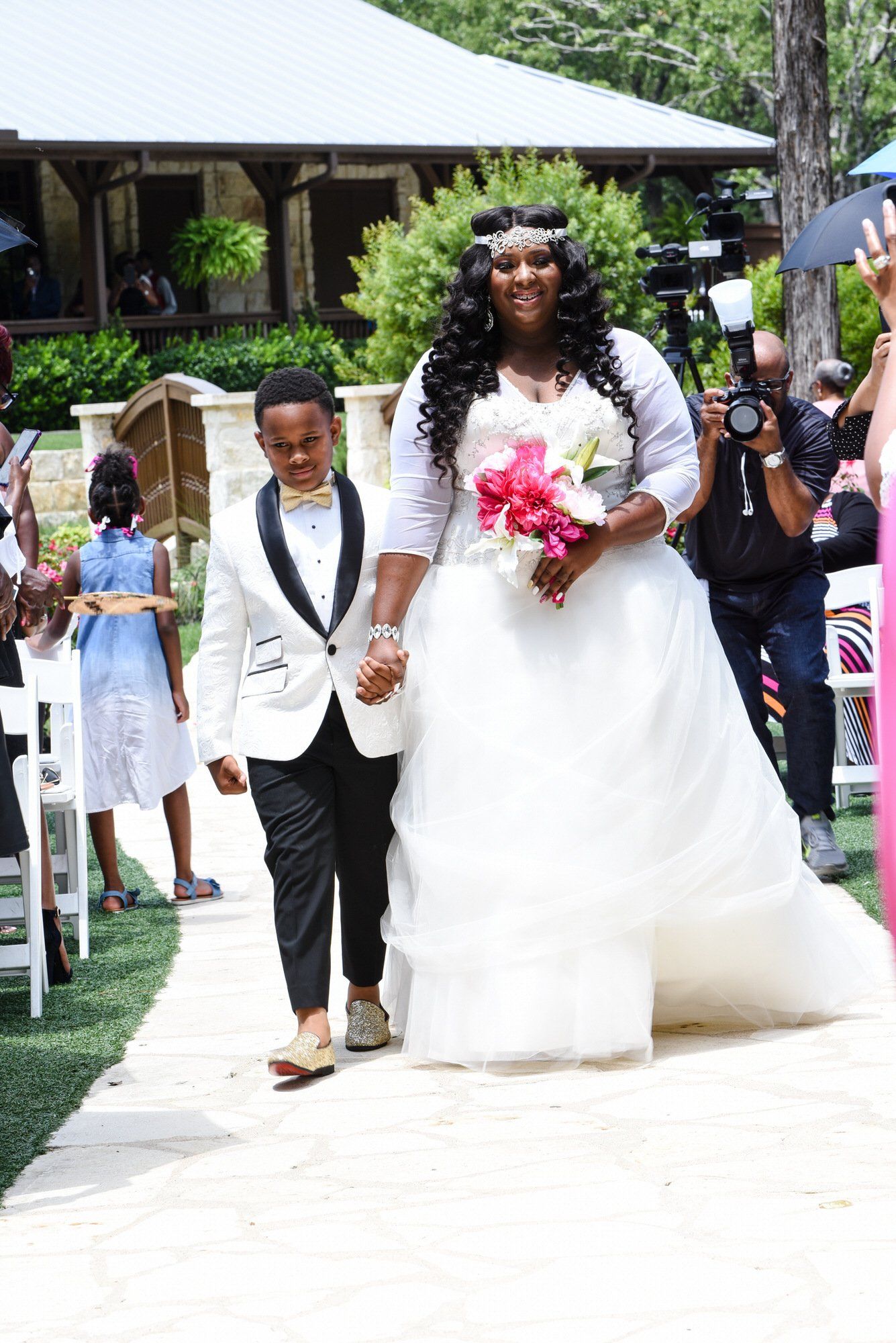a bride and groom are walking down the aisle at their wedding holding hands .