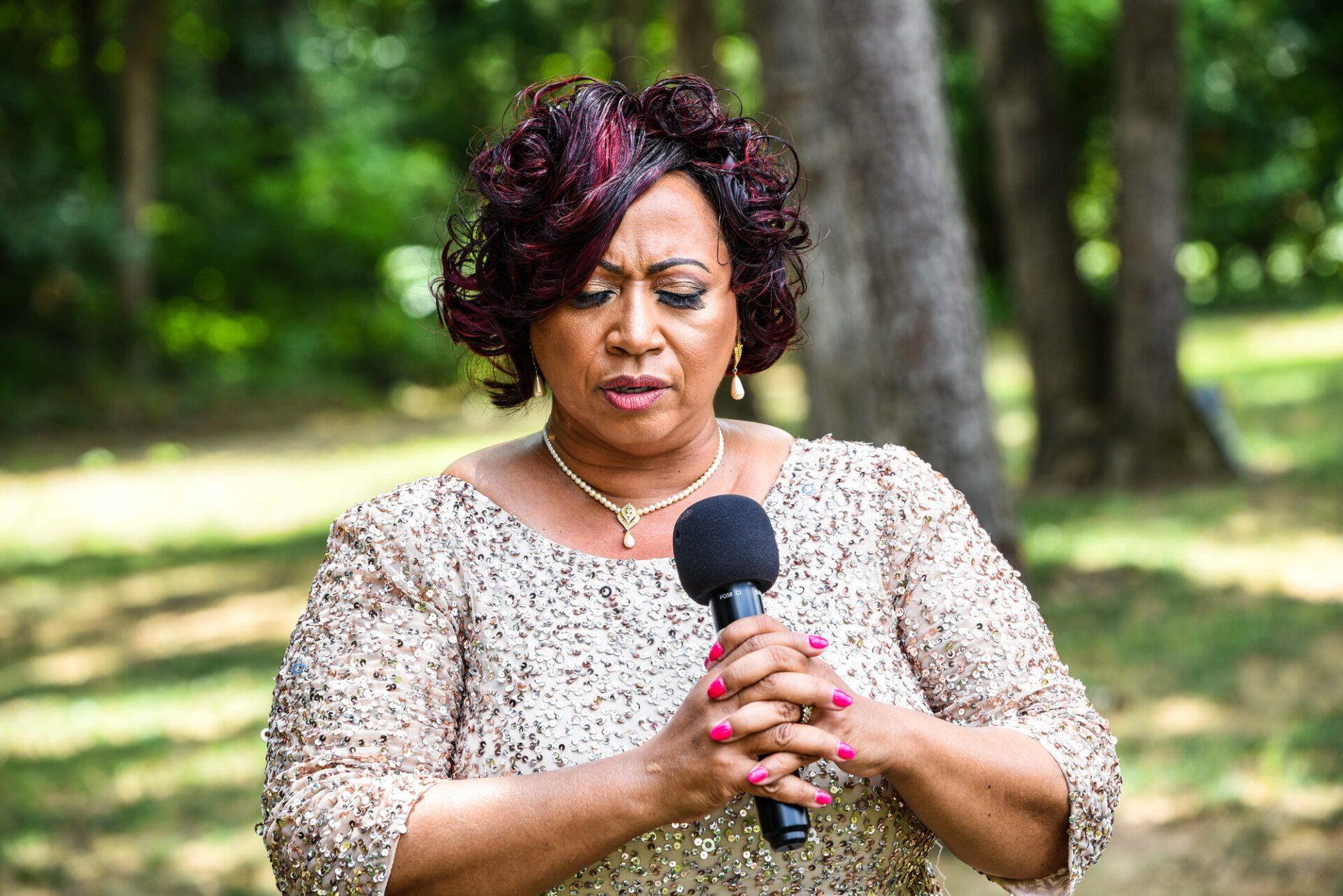 a woman is singing into a microphone in a park .