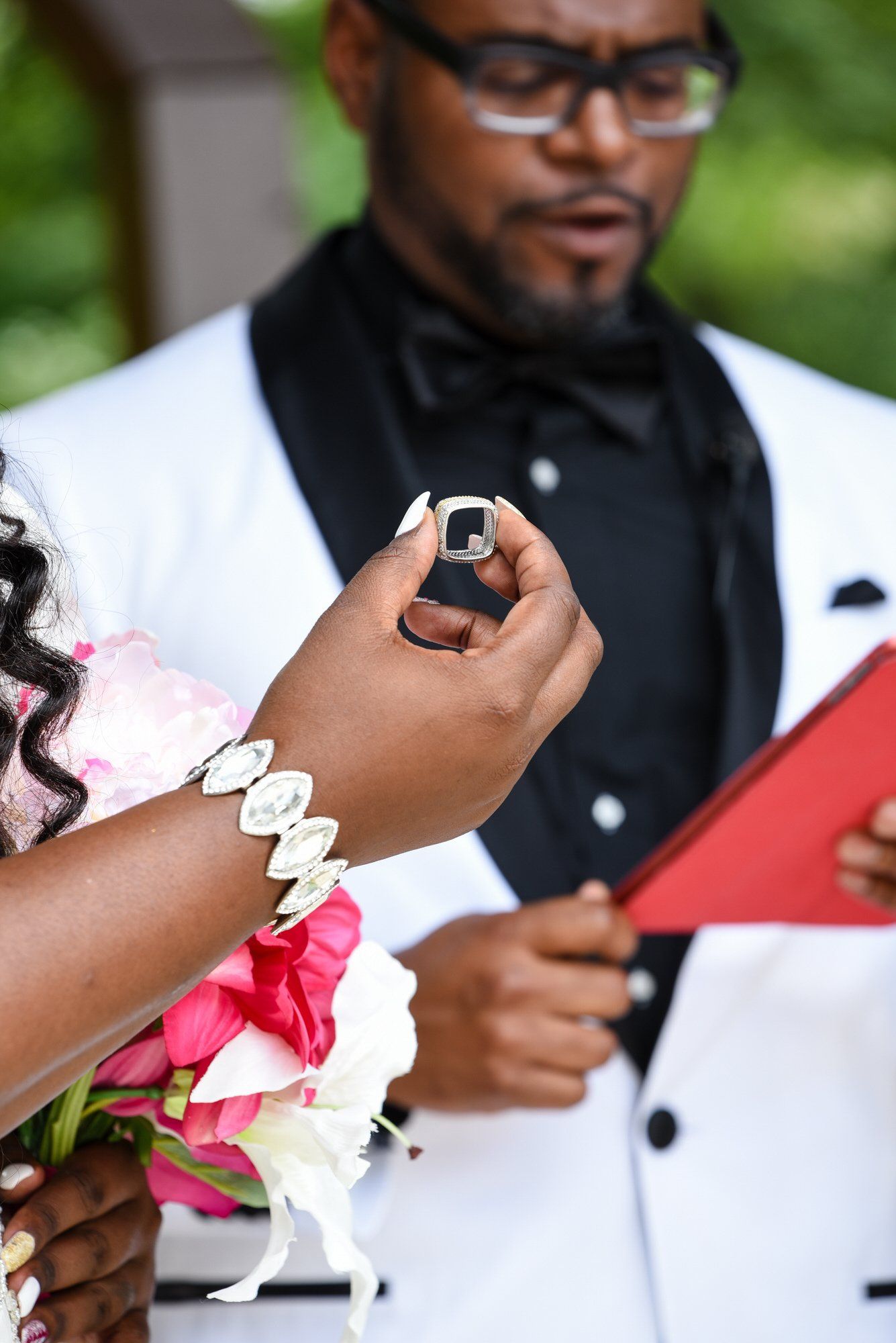 a woman is holding a ring in front of a man in a tuxedo .