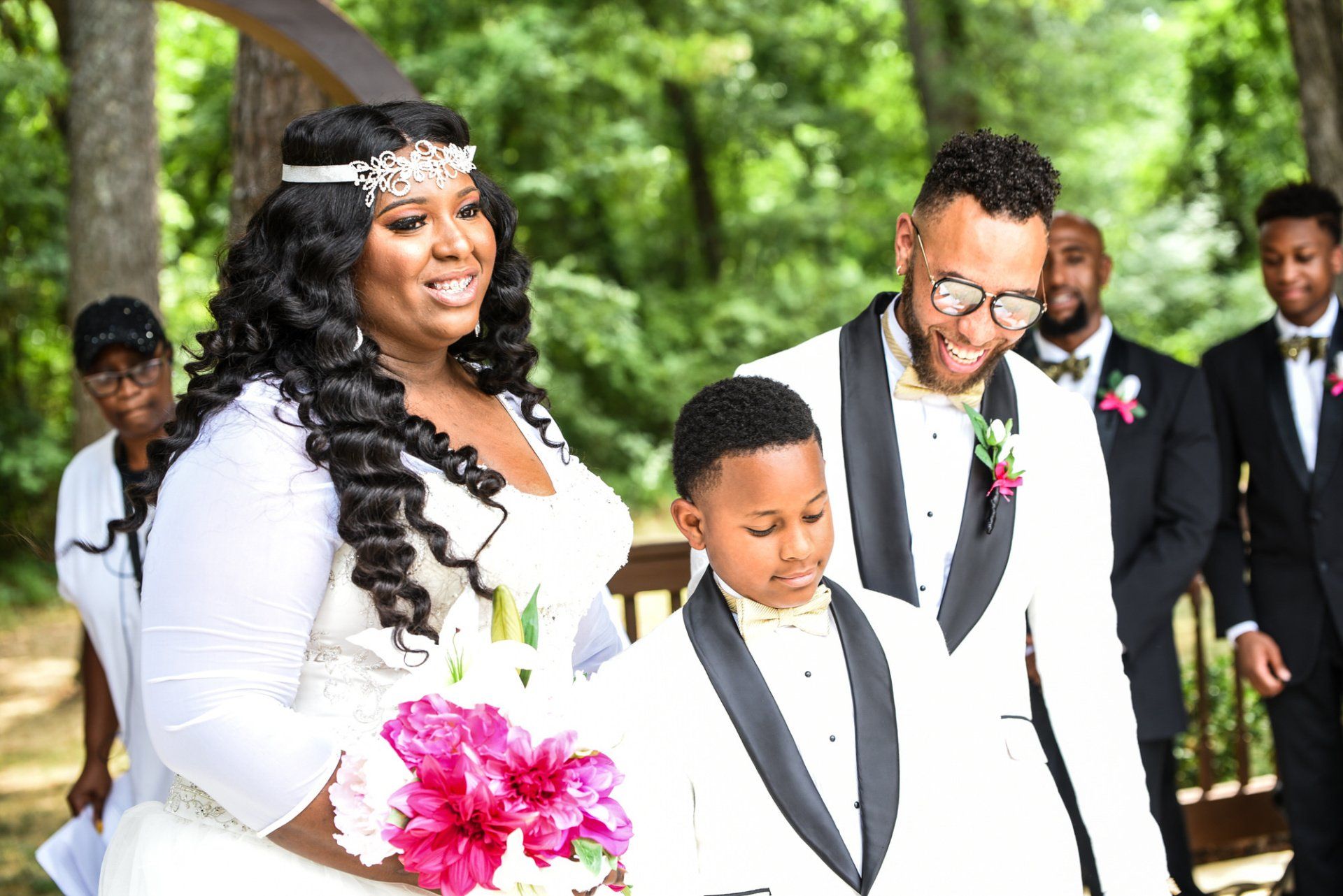 a bride and groom are walking down the aisle with their son .