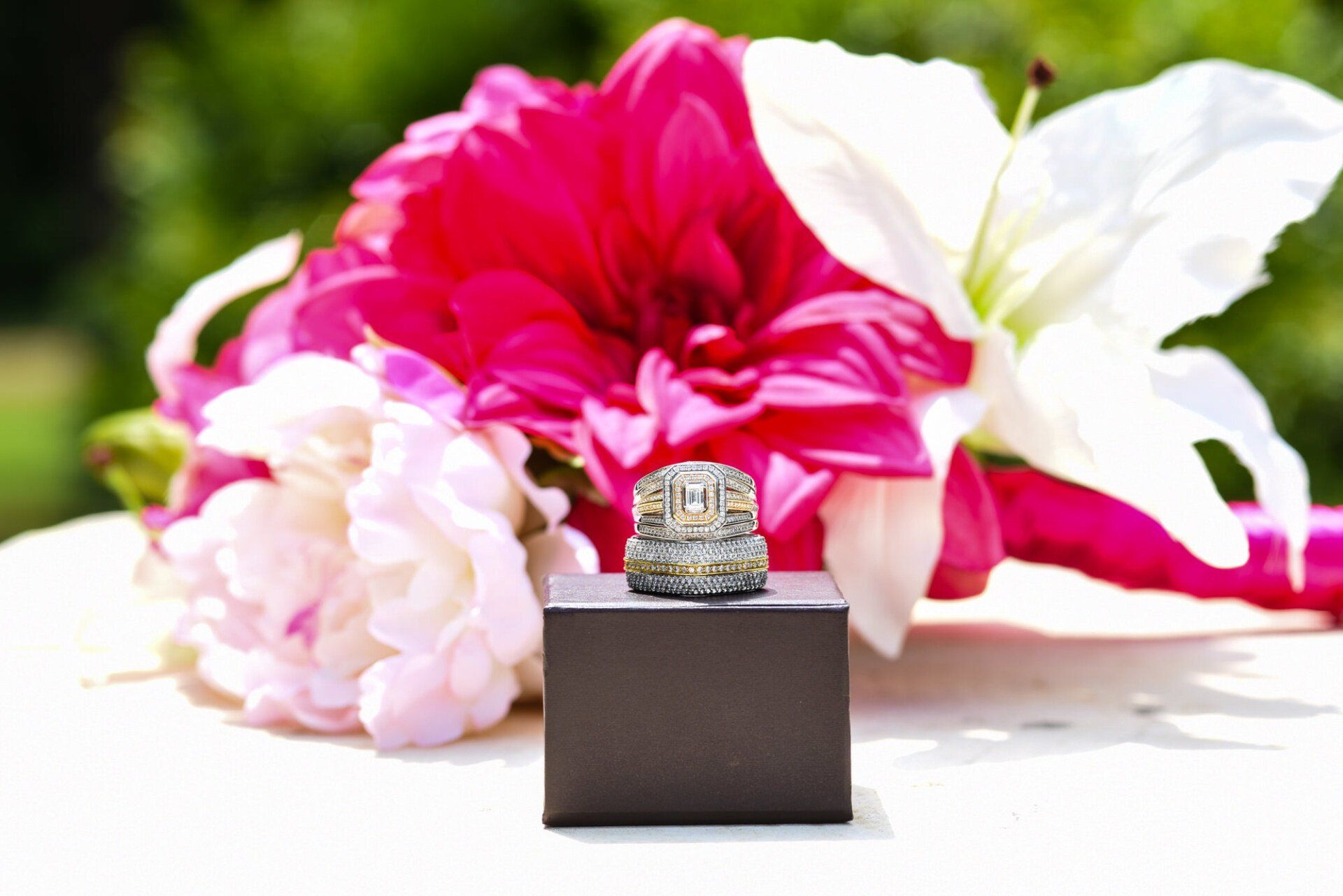 a ring sits on a box in front of flowers